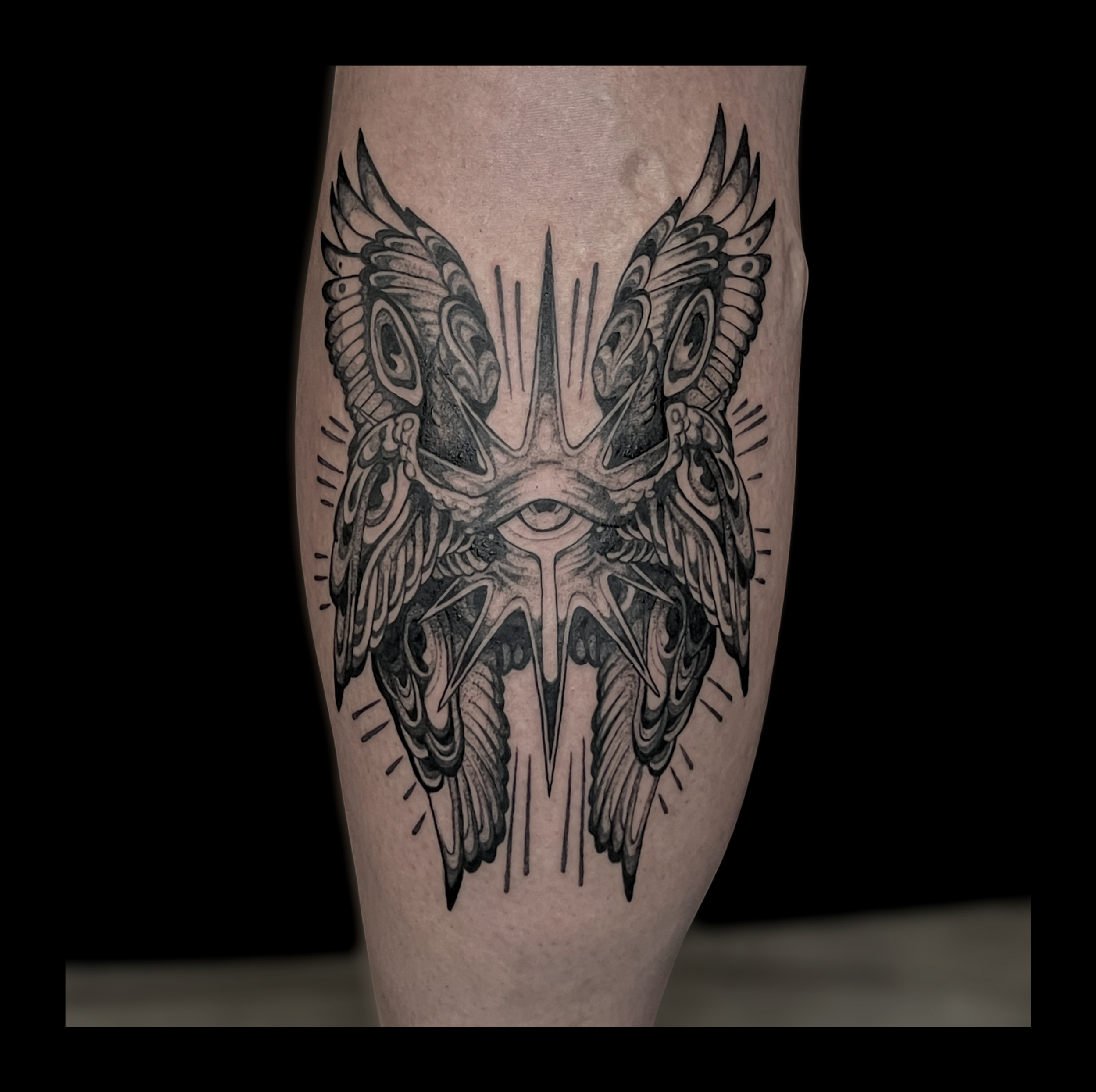 Black and gray tattoo of a butterfly with intricate wing patterns on a person's arm.