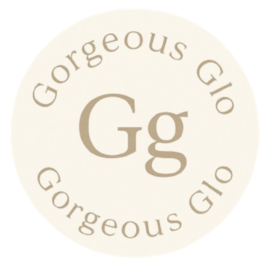 A circular logo with the text 'Gorgeous Glo' curving around the top and bottom, and a large letter 'Gg' in the center, all in beige on a light cream background.