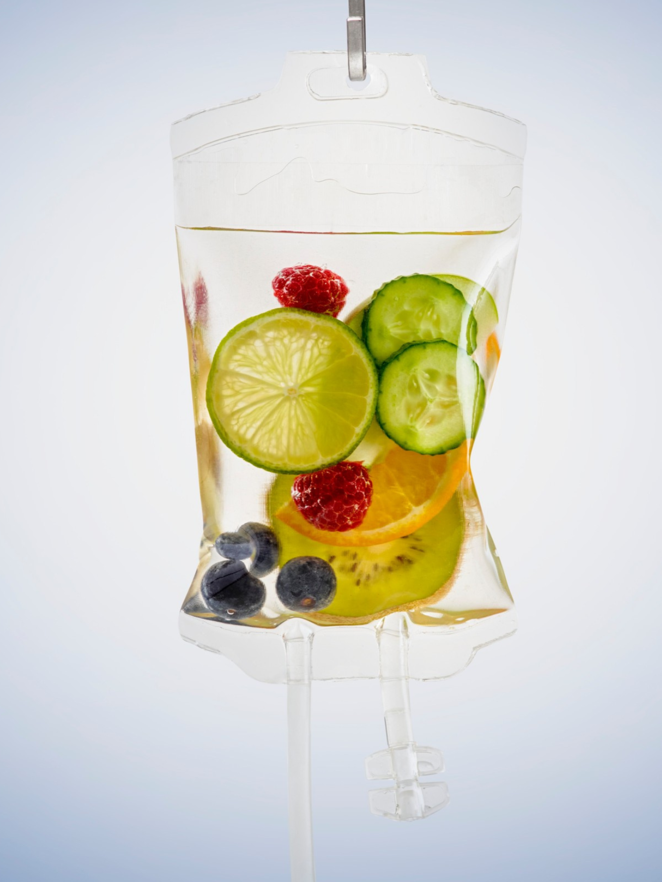 A lollipop shaped like a clear plastic bag filled with floating slices of lemon, cucumber, orange, raspberry, blueberry, and other fruits.