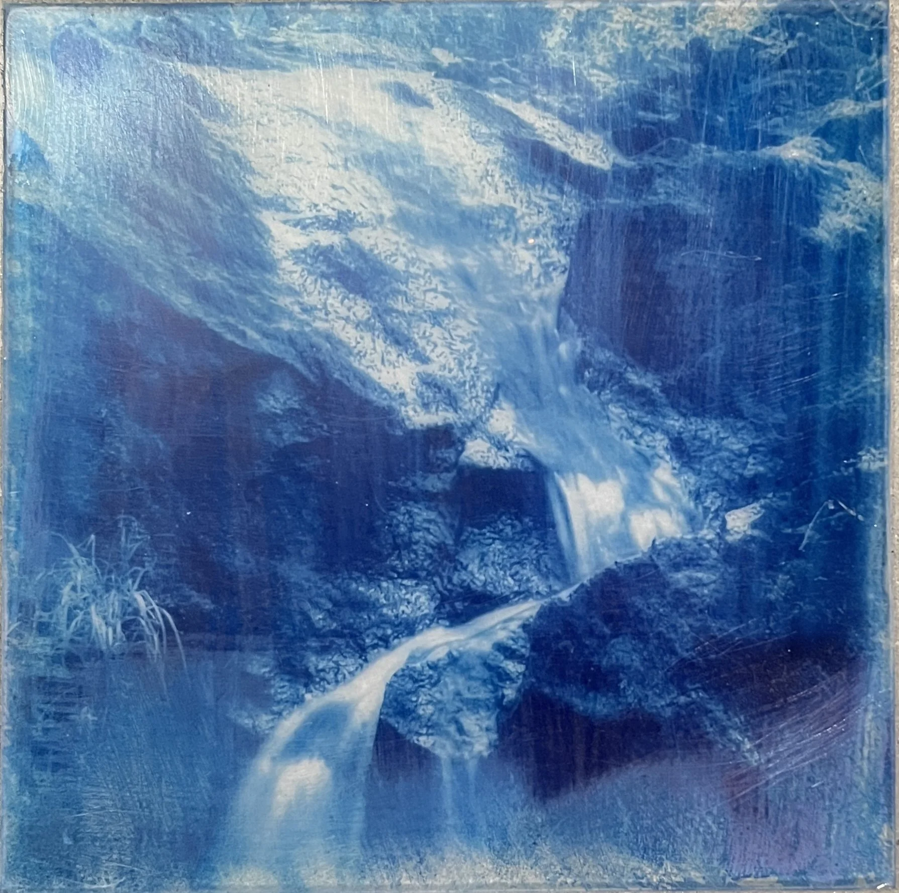 Painting of a waterfall flowing over rocks with surrounding landscape in blue shades.