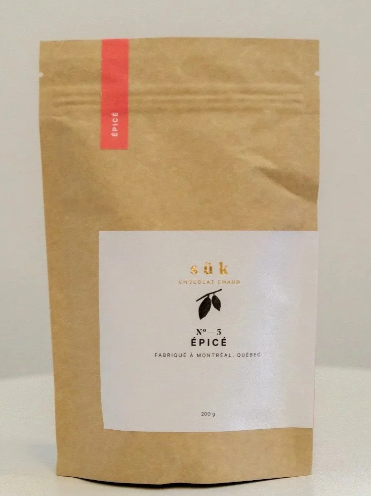 Un emballage de poudre de chocolat chaud nommé 'N° 5 Épicé', fabriqué à Montréal, Québec.
