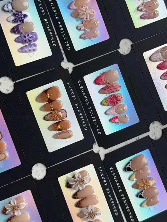 Échantillons de faux ongles avec des designs floraux et artistiques dans un album de manucure.