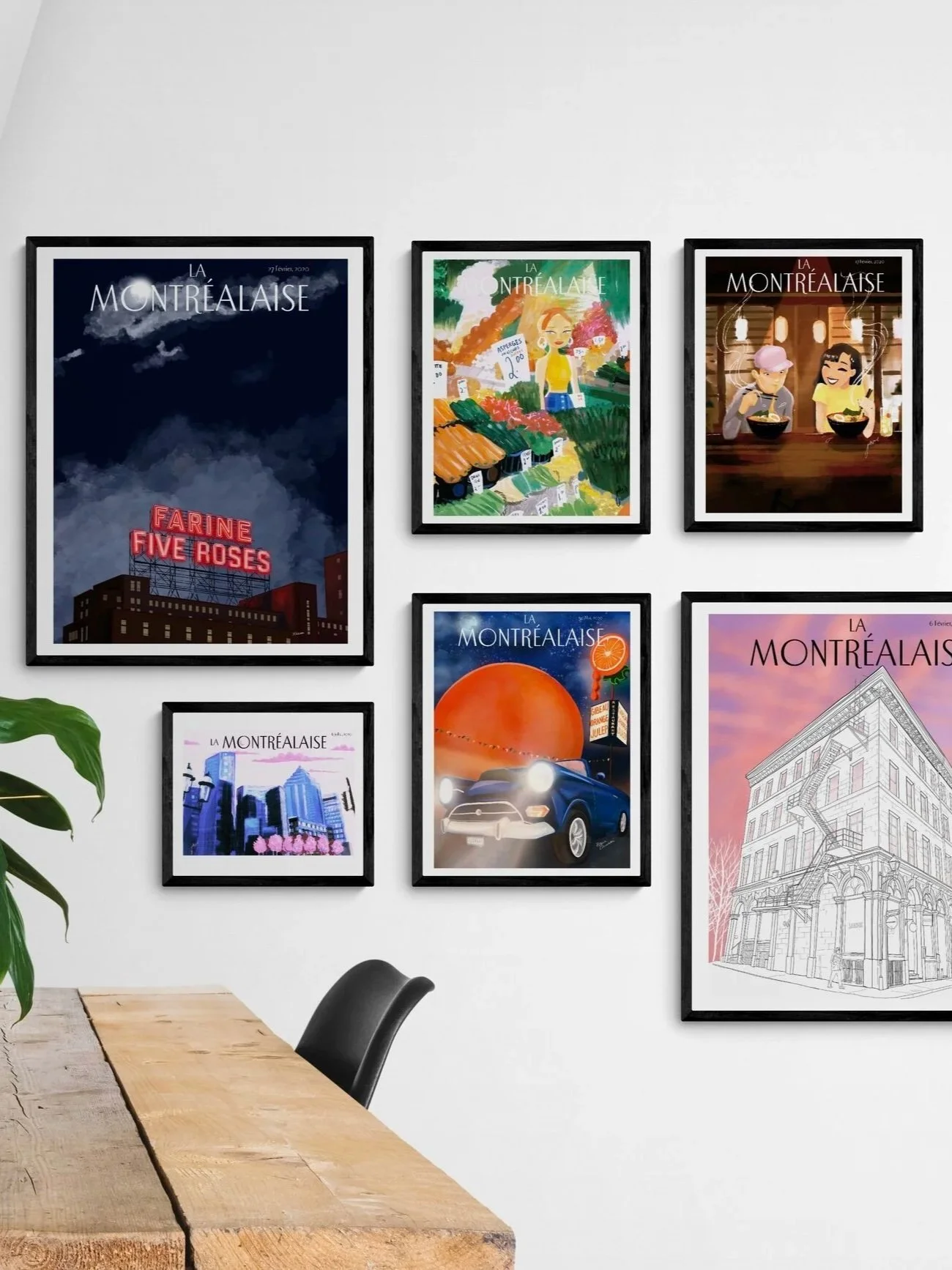 Une galerie de posters représentant Montréal dans un cadre noir, affichant différentes illustrations et photographies de la ville, accrochés à un mur blanc au-dessus d'une table en bois avec un fauteuil noir.