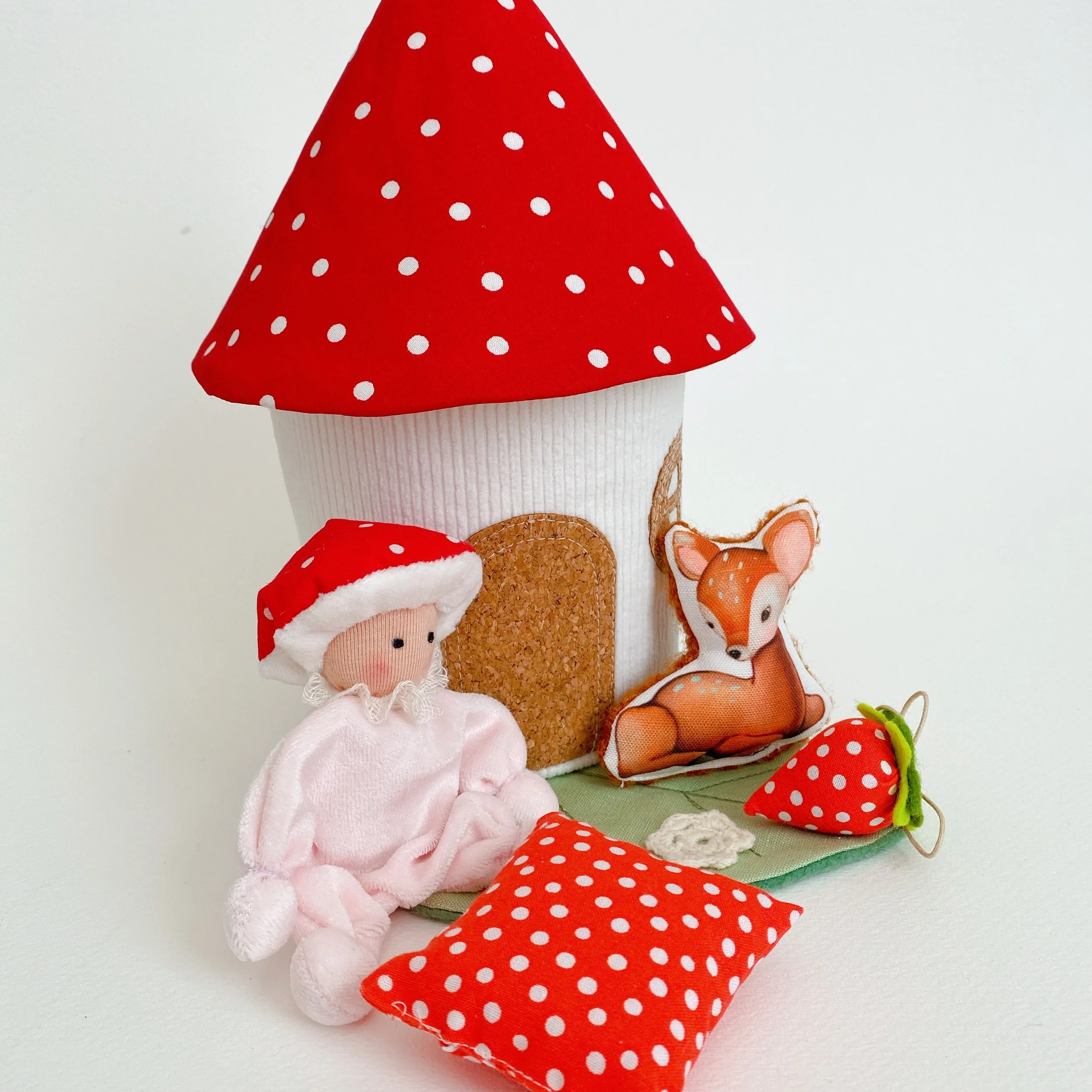 Une collection de petites poupées en tissu, avec des motifs à pois, représentant des animaux et des personnages, présentée sur un fond blanc.