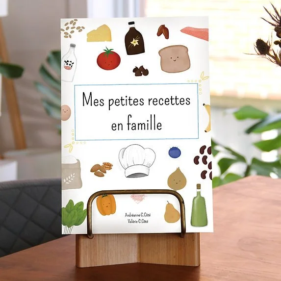 Couverture d'un livre intitulé "Mes petites recettes en famille" avec des illustrations de divers ingrédients et objets de cuisine autour du titre.