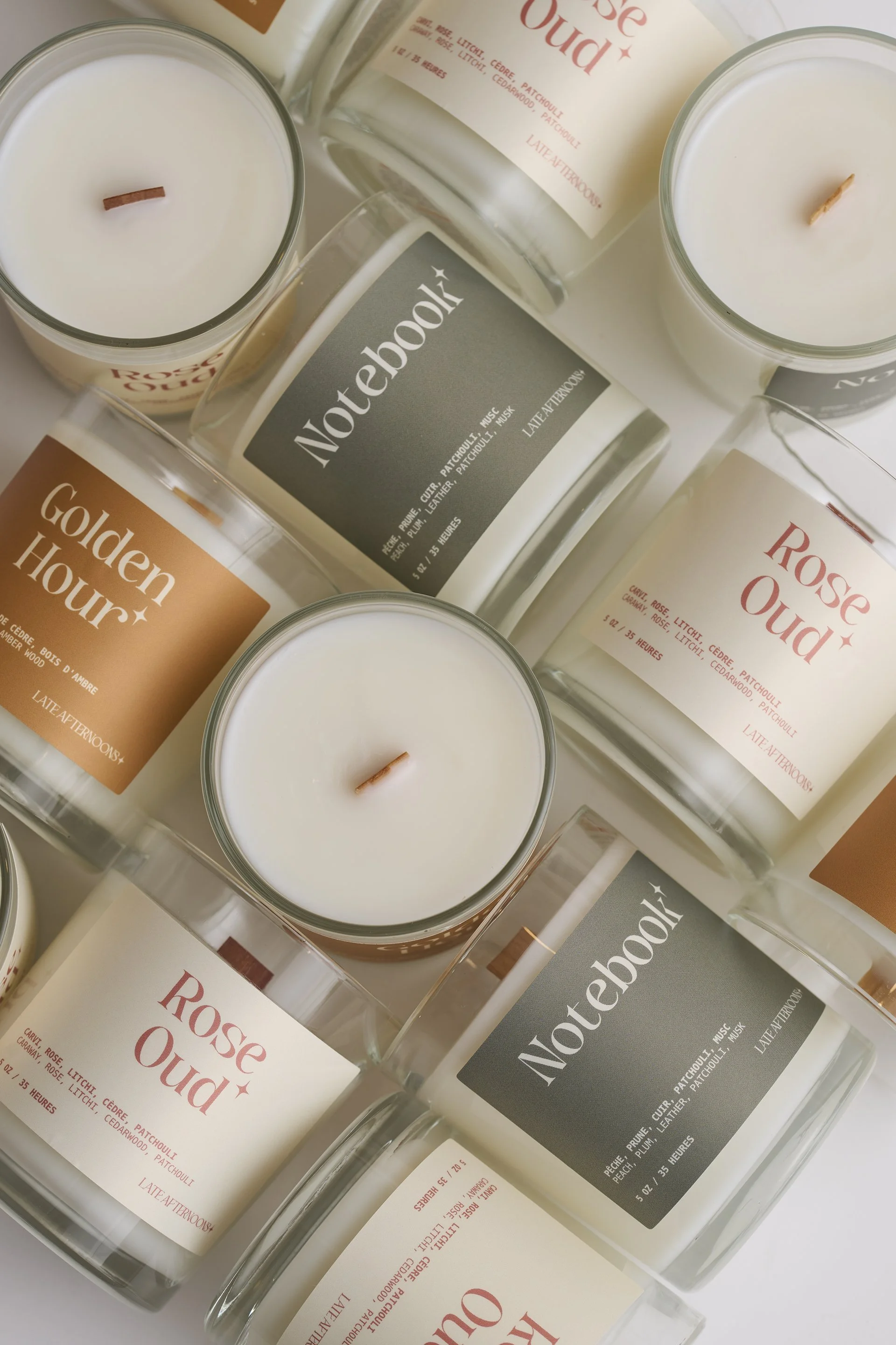 Bougies parfumées dans des contenants en verre avec étiquettes colorées, disposées en enchevêtrement.