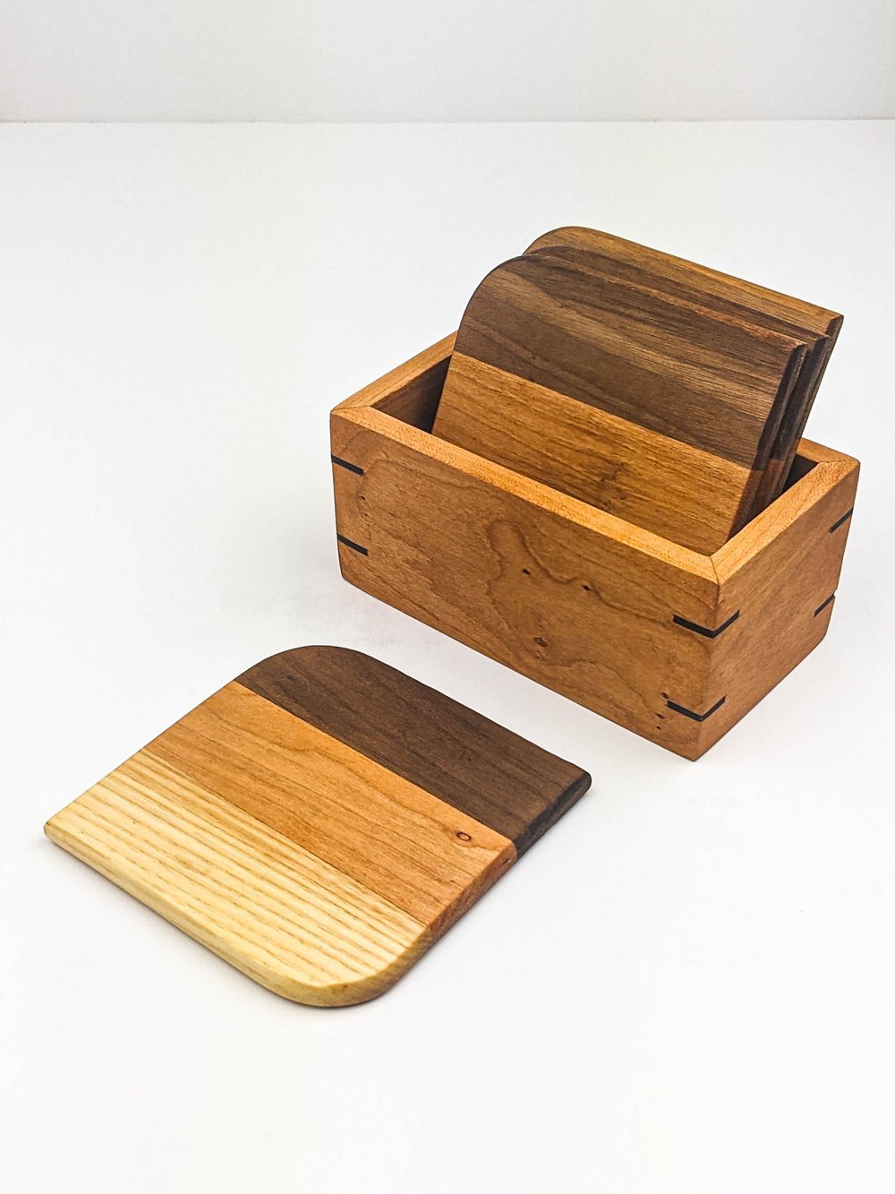 Un ensemble de planches de bois de différentes nuances, avec une boîte en bois et une planche posée à côté.
