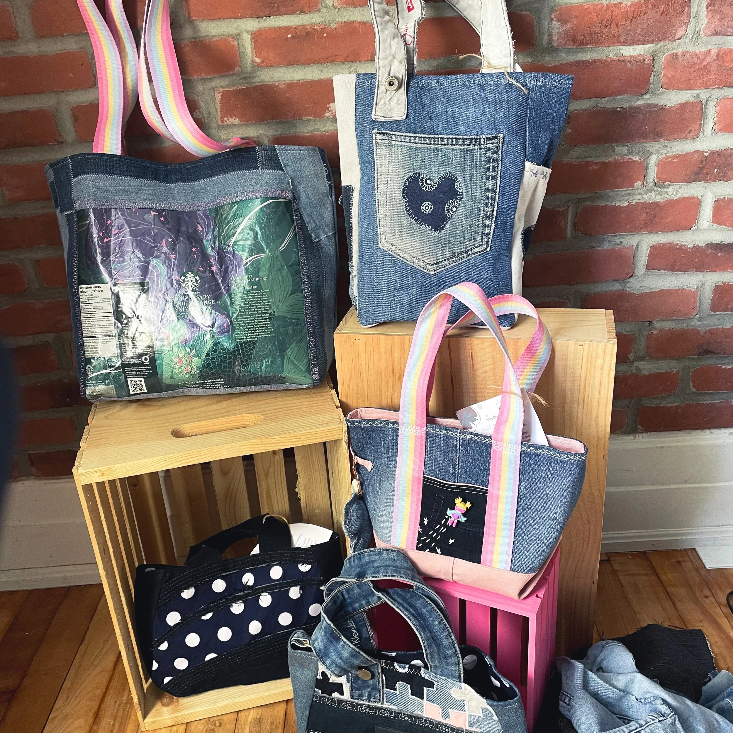 Sac à dos créé à partir de jeans recyclés avec une poche à cœurs brodés et des bretelles en ruban coloré