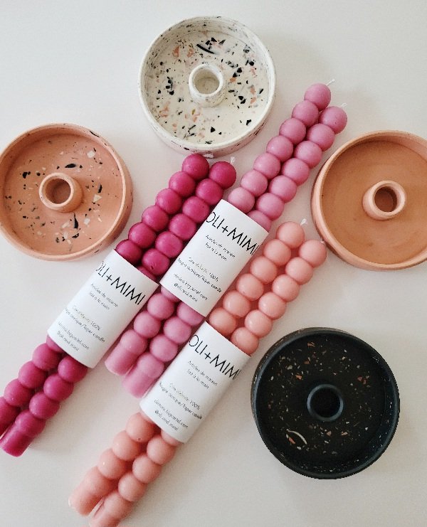 Bougies décoratives de différentes couleurs avec trois bâtons de boules de décoration en rose, beige et noir