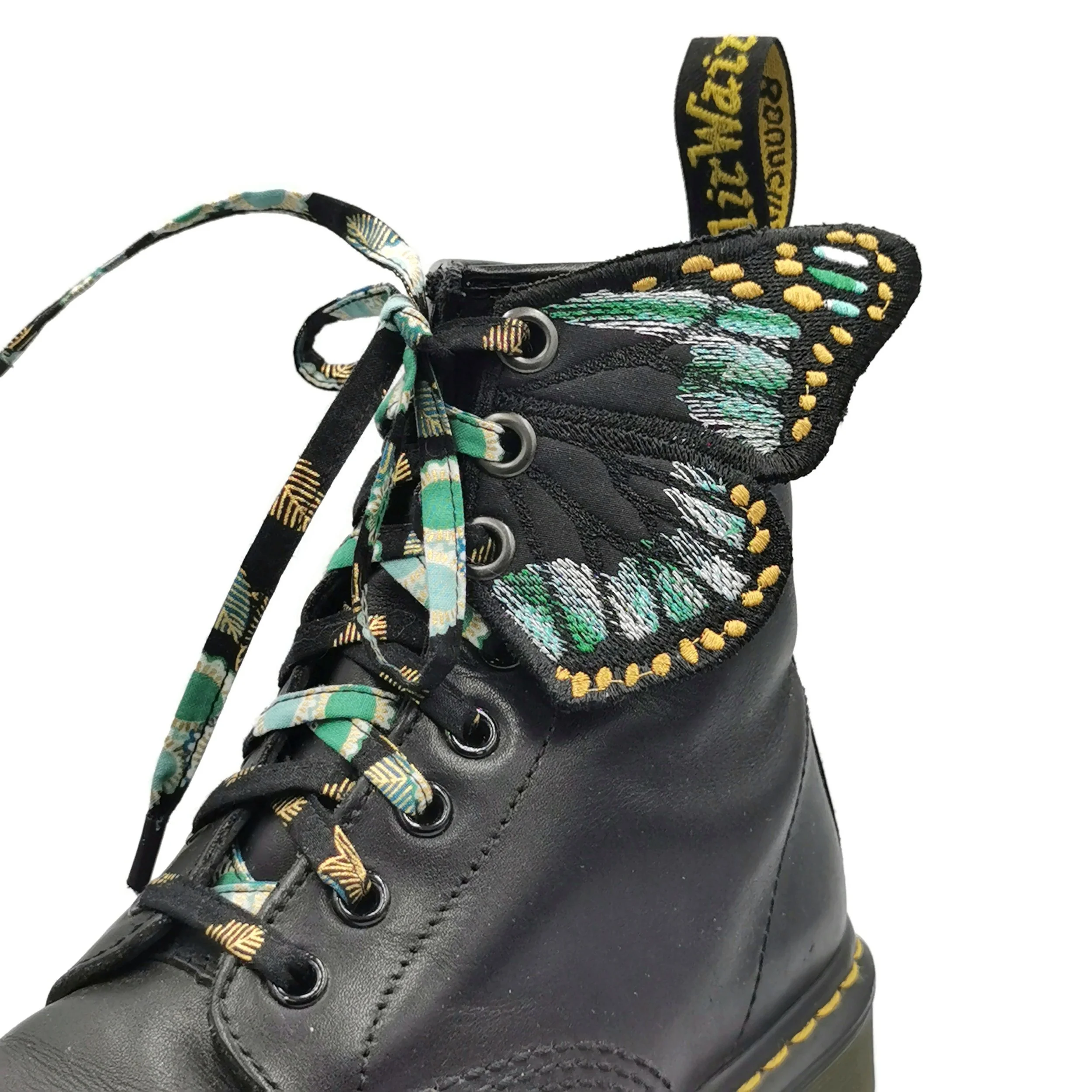 Une chaussure noire de style bottine, avec des lacets colorés et une doublure à motif coloré, affichée en gros plan.