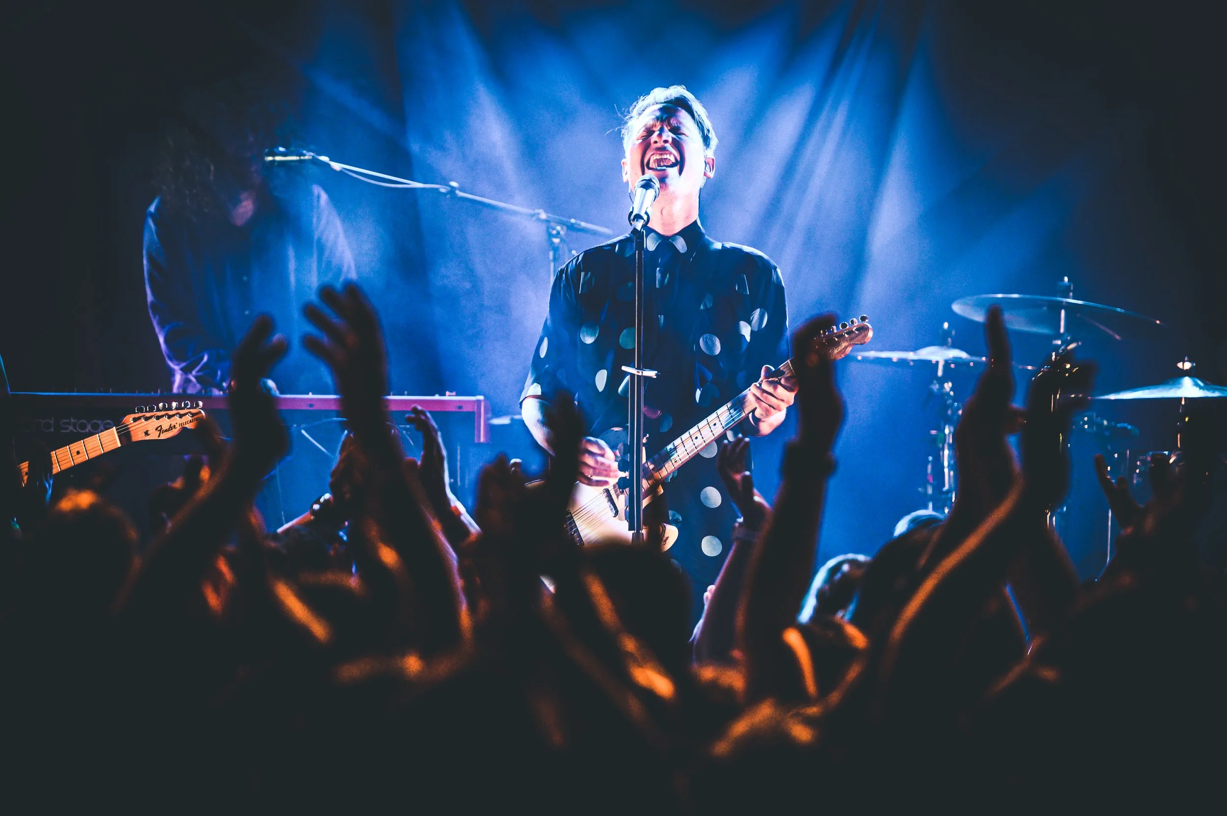 Konzertfotografie Schweiz – Band Hecht live auf der Bühne mit begeisterter Crowd und intensiver Lichtstimmung