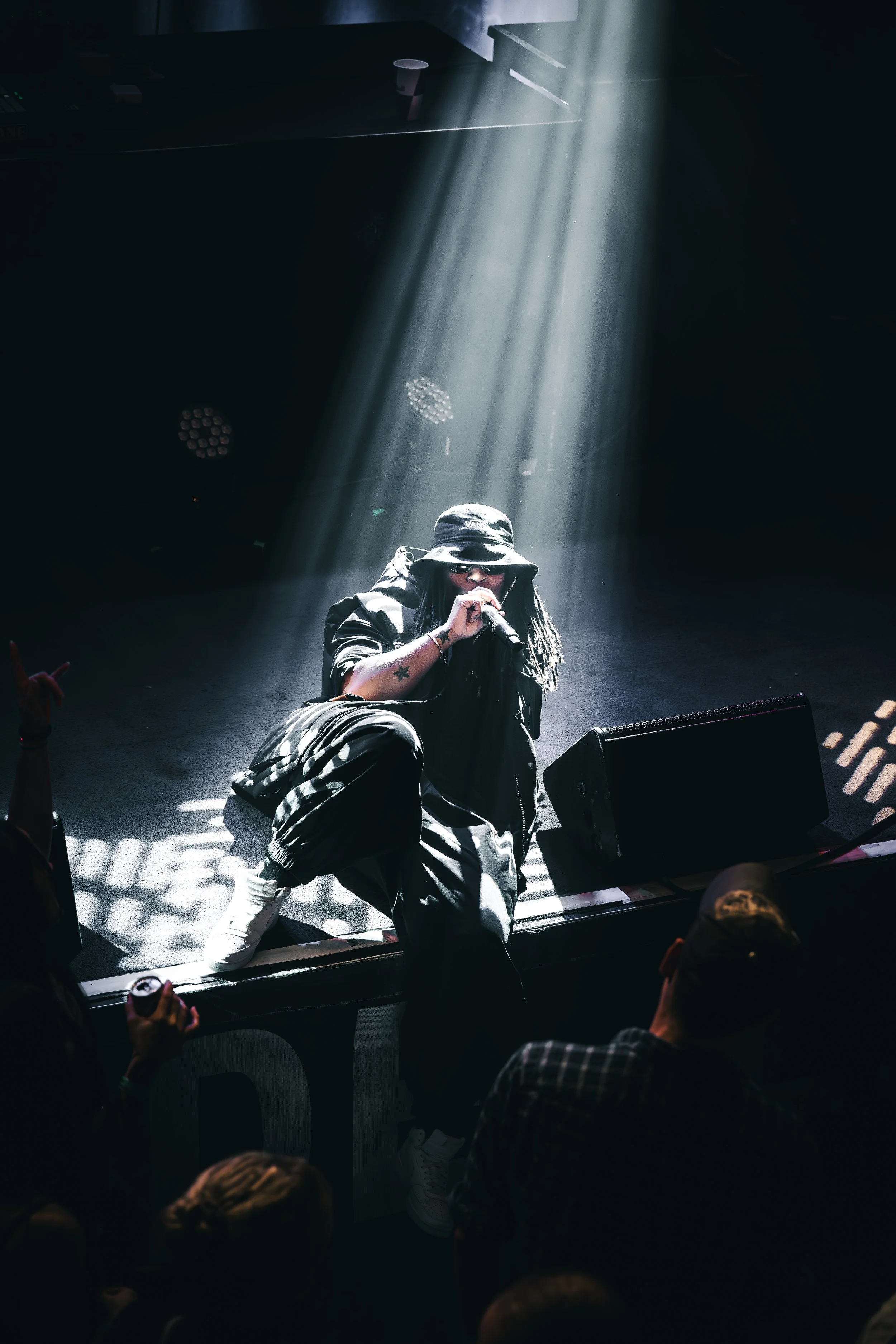 Konzertfotografie Schweiz – Hip-Hop Künstler live auf der Bühne im Spotlight mit intensiver Atmosphäre