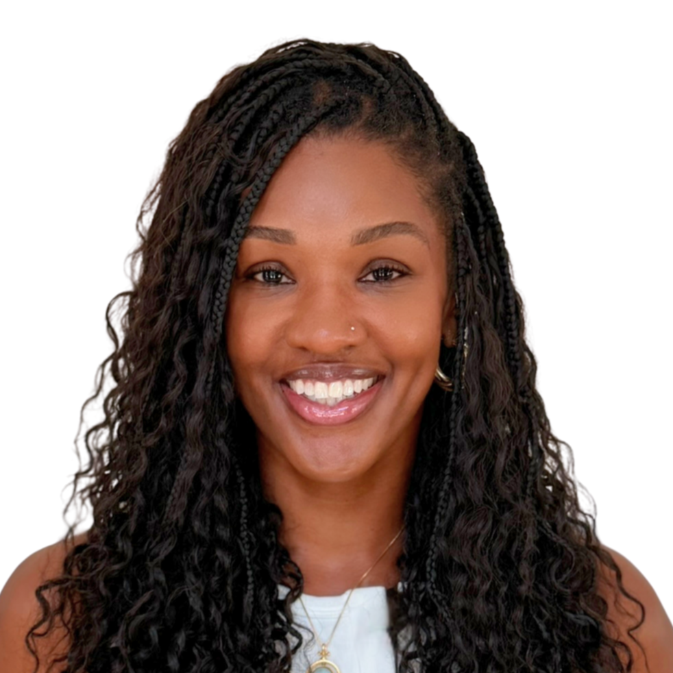 A woman with long, dark curly hair smiling at the camera, wearing a white top, small earrings, and a necklace, against a white background.