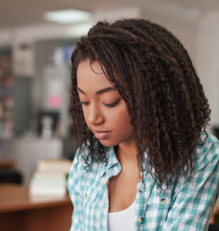 A young woman looks down thoughtfully in a welcoming environment that reflects support and personal growth.