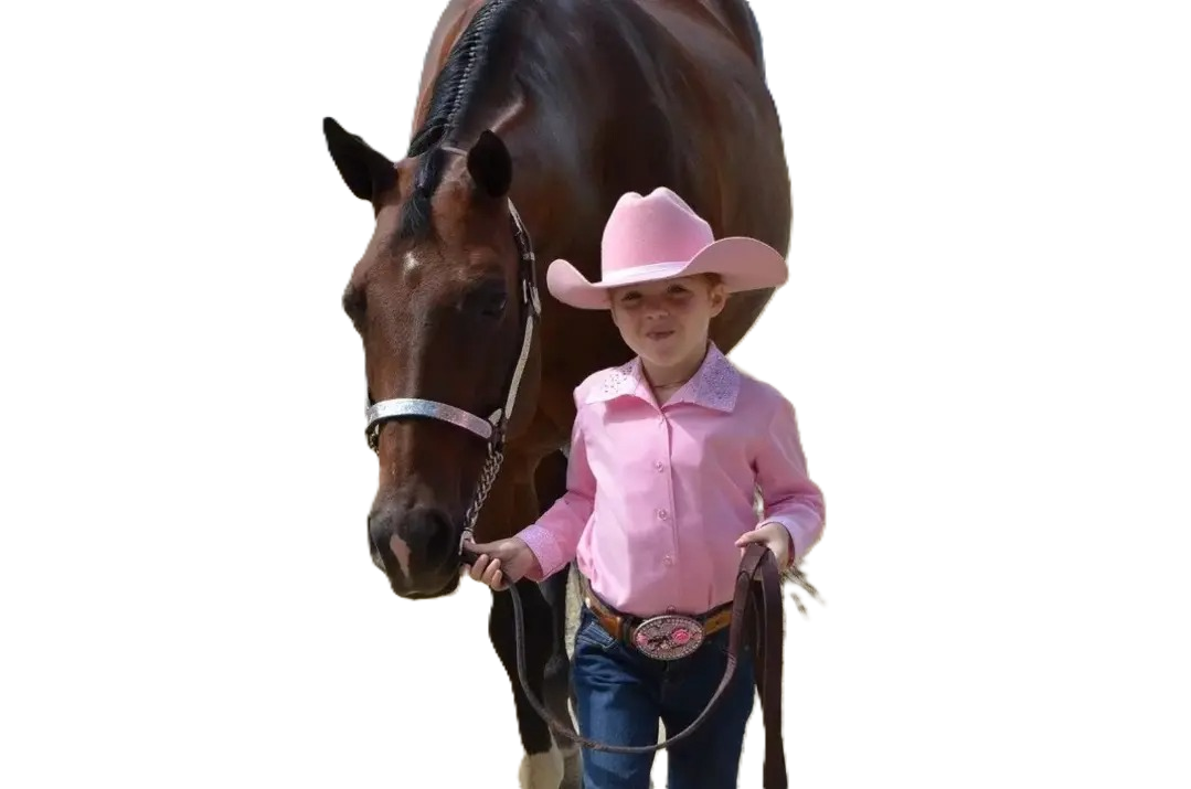 Young girl dressed in Western attire, wearing a pink cowboy hat and pink shirt, holding a lead rope of a brown horse with a white blaze on its face.