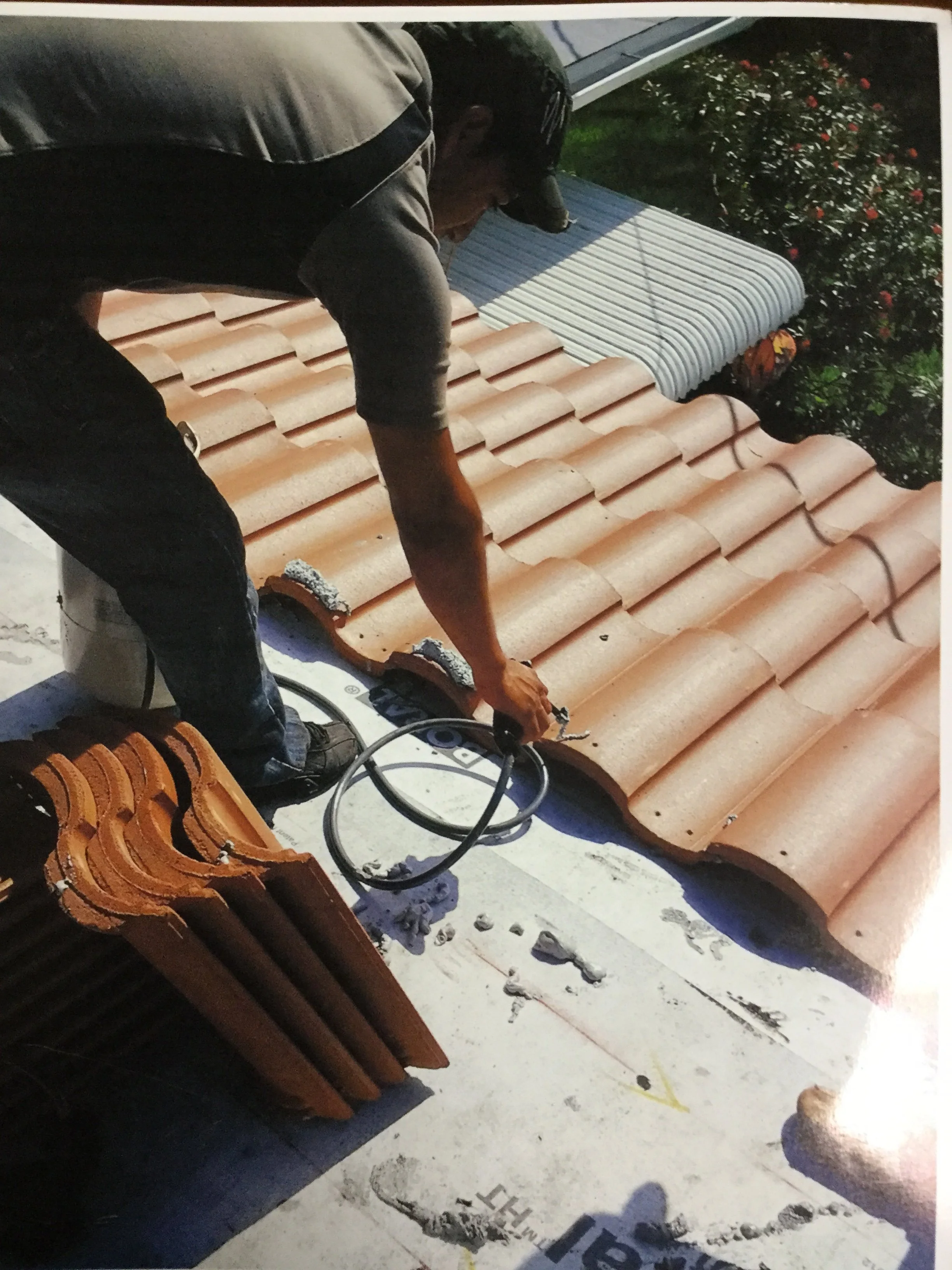 Roofer repairing barrel tile roof