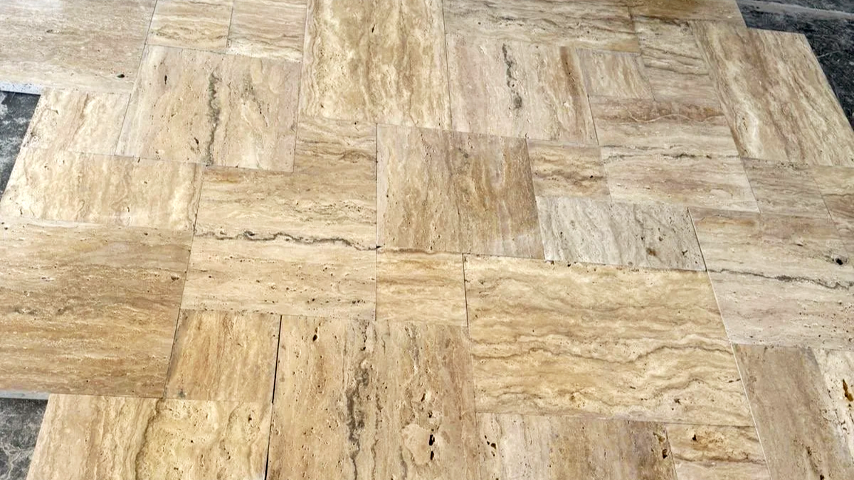 Close-up of a beige marble tile floor with various natural stone patterns and veining.