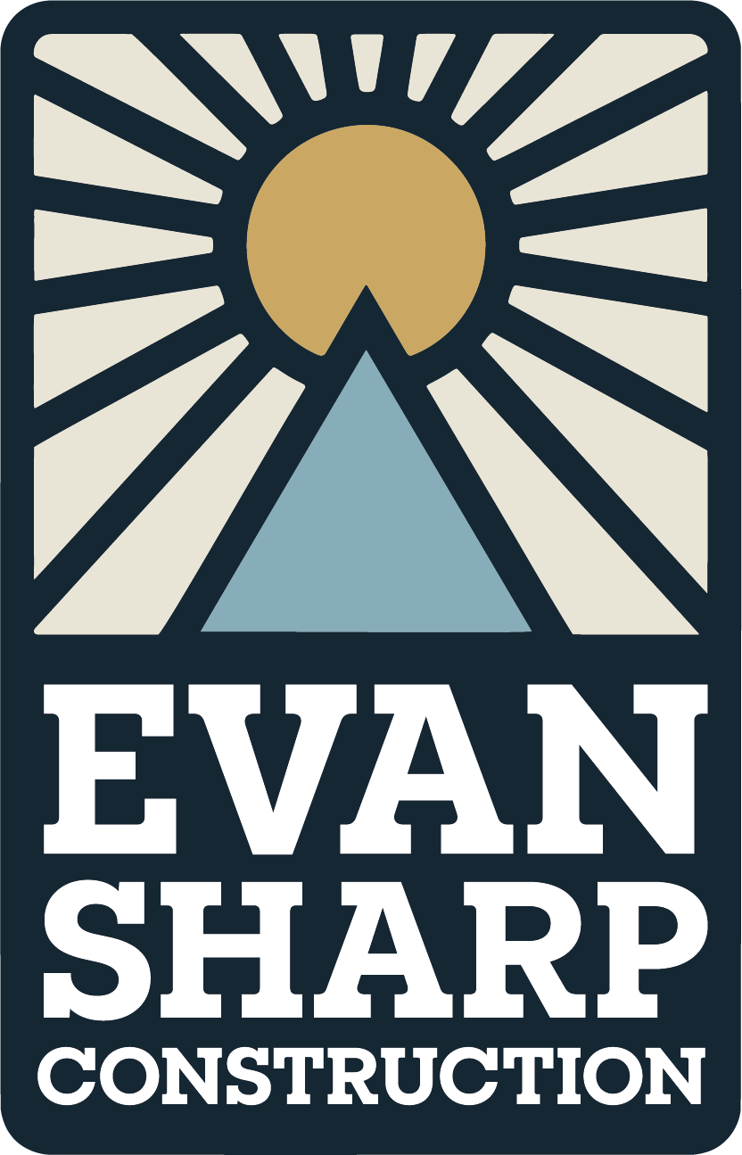 Logo for Evan Sharp Construction featuring a rising sun, stylized mountain, and bold text.