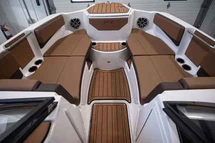 Interior of a boat with brown cushioned seats and wood flooring.