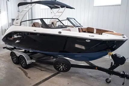 A black and white motorboat on a trailer inside a warehouse or garage.