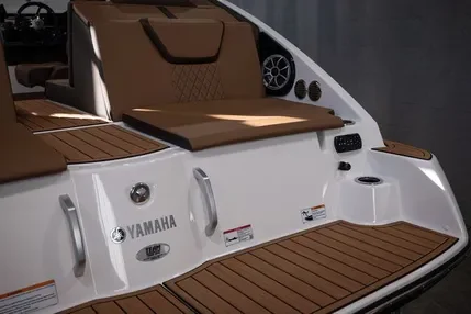 Part of a Yamaha boat with brown cushioned seats and wooden deck