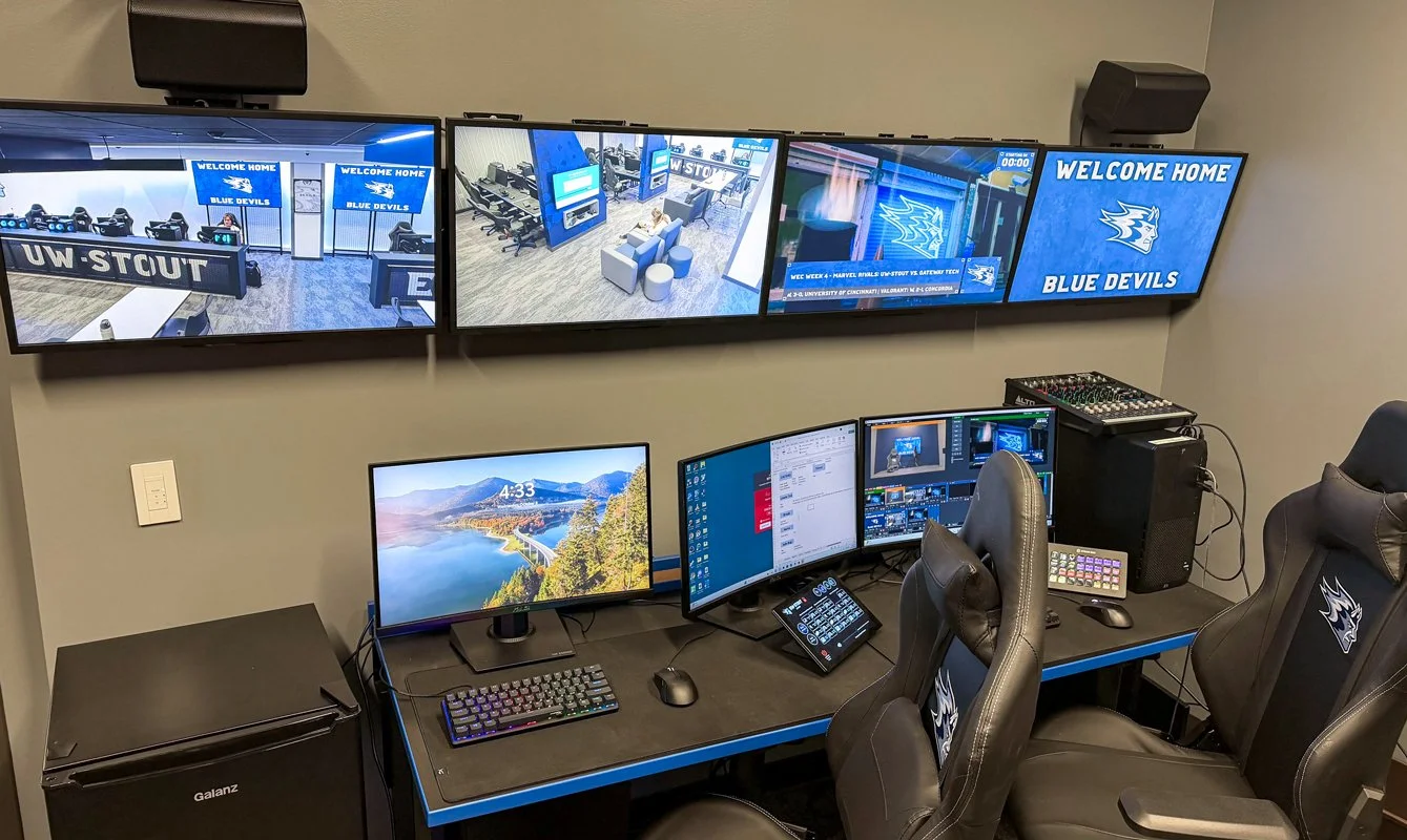 UW-Stout Polytechnic Esports Arena production control station featuring multiple video monitors, live streaming equipment, audio mixer, and integrated AV controls.