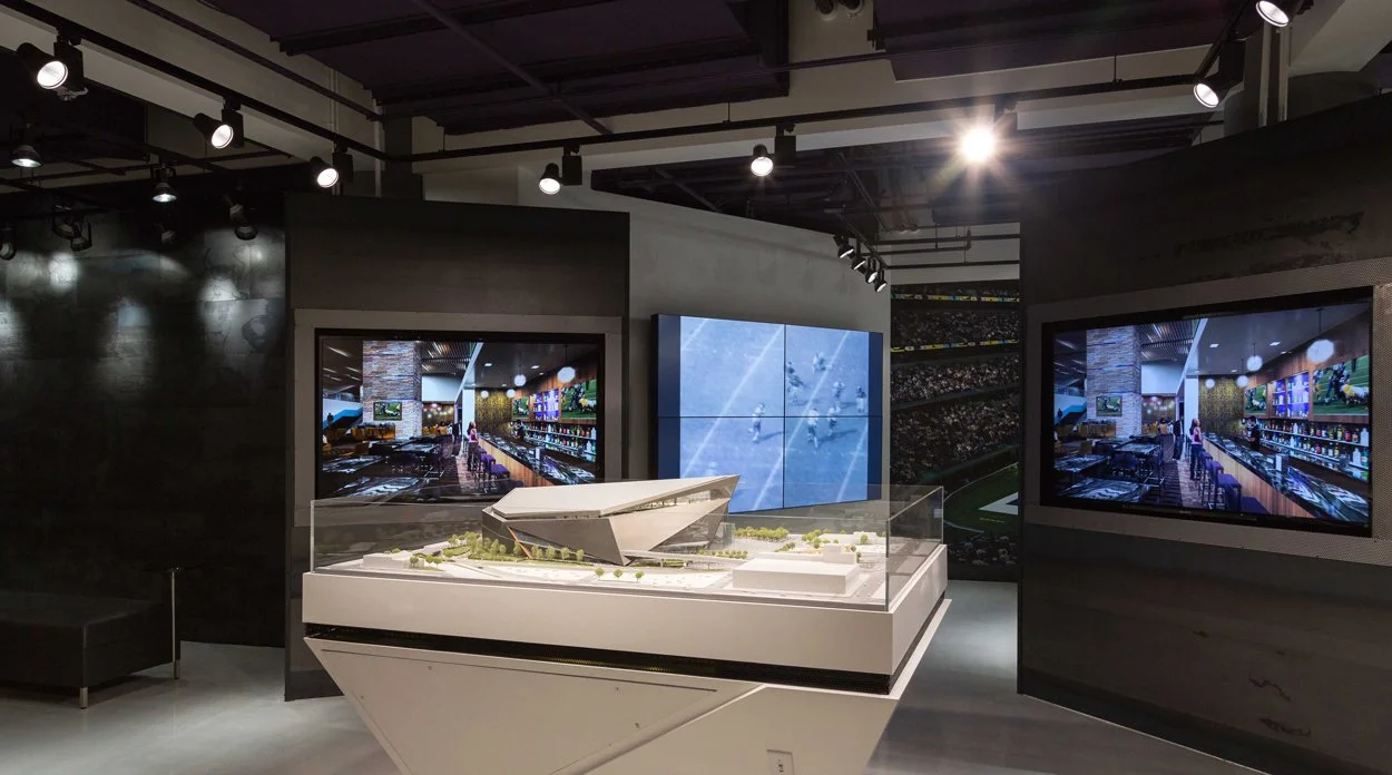 Minnesota Vikings U.S. Bank Stadium Preview Center in Minneapolis featuring interactive video displays, a multi-screen video wall, and a stadium model.