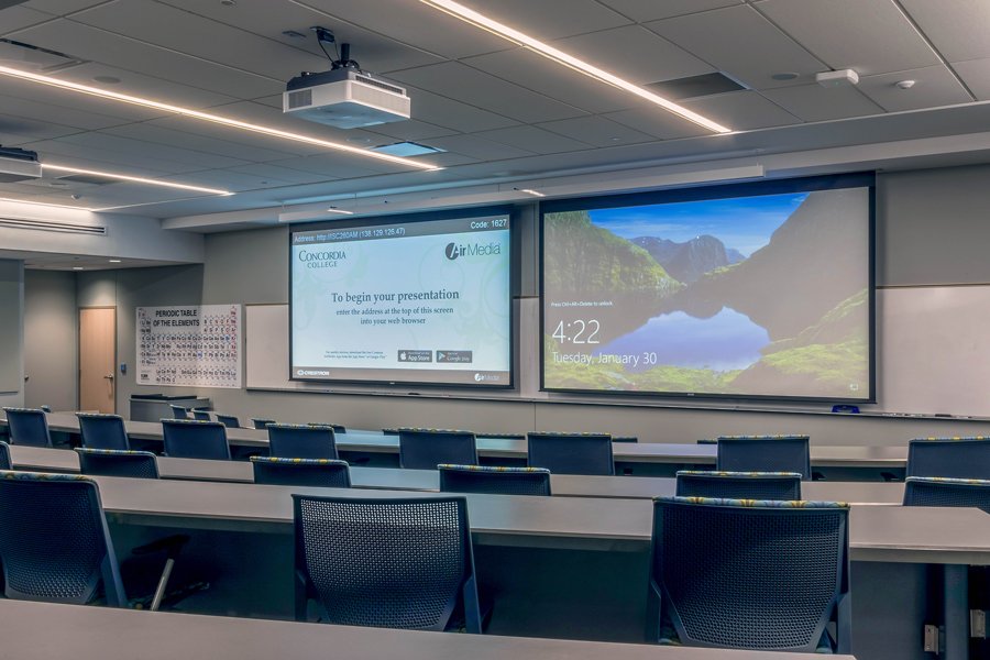 Concordia College classroom featuring dual projection screens, ceiling-mounted projector, and integrated presentation technology for higher education.
