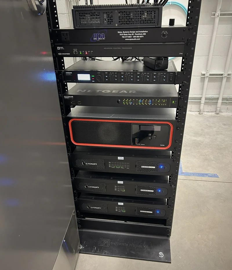 Professional audio equipment rack with amplifiers and network components for the Hasse Ryt-Way Arena sound system.
