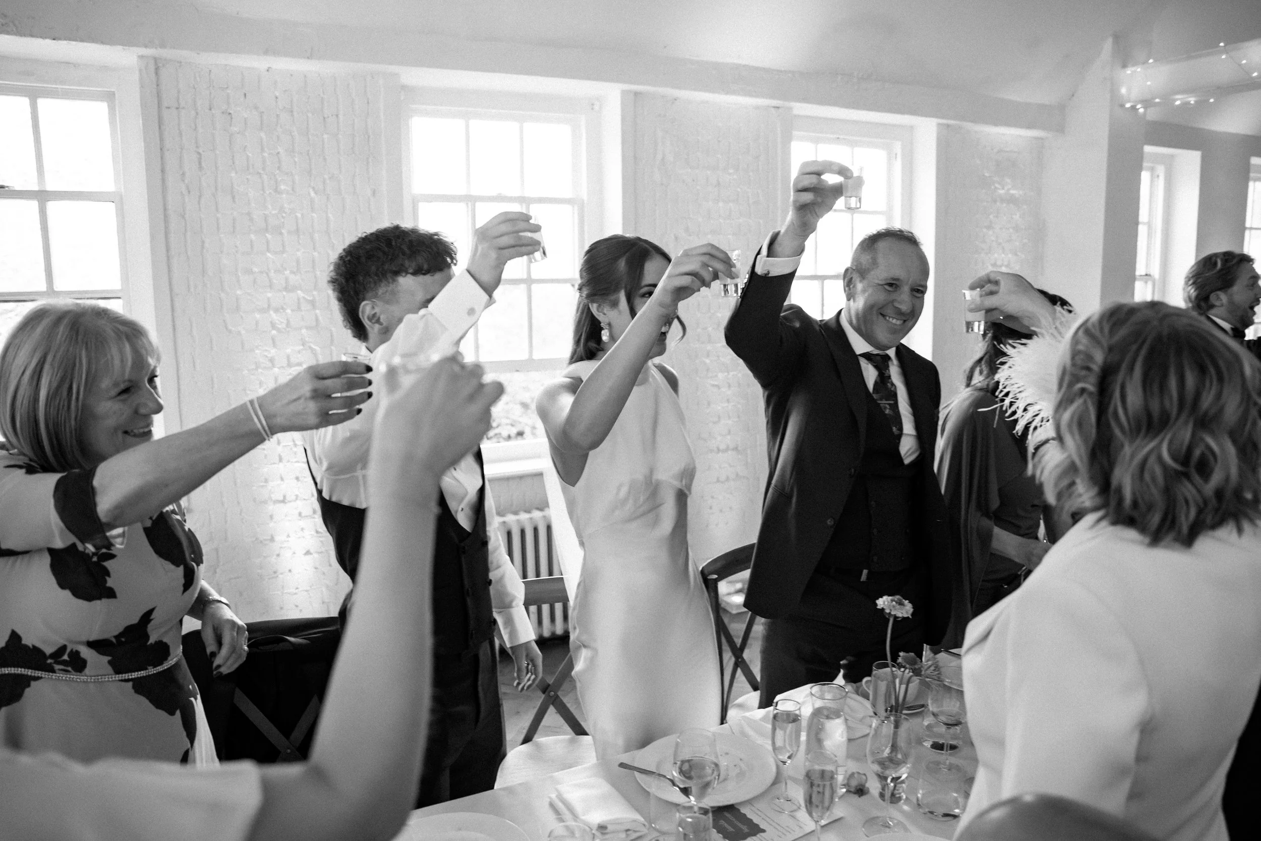 People raising glasses in a toast during a celebration at a social gathering or party.