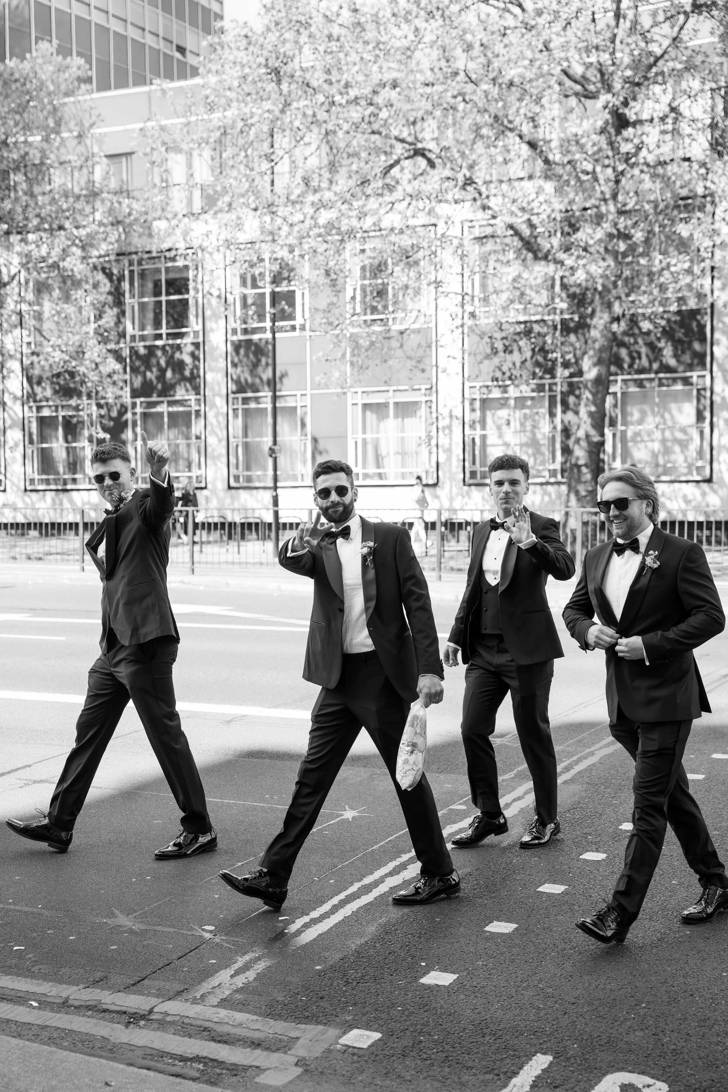 Groomsmen crossing city street before wedding
