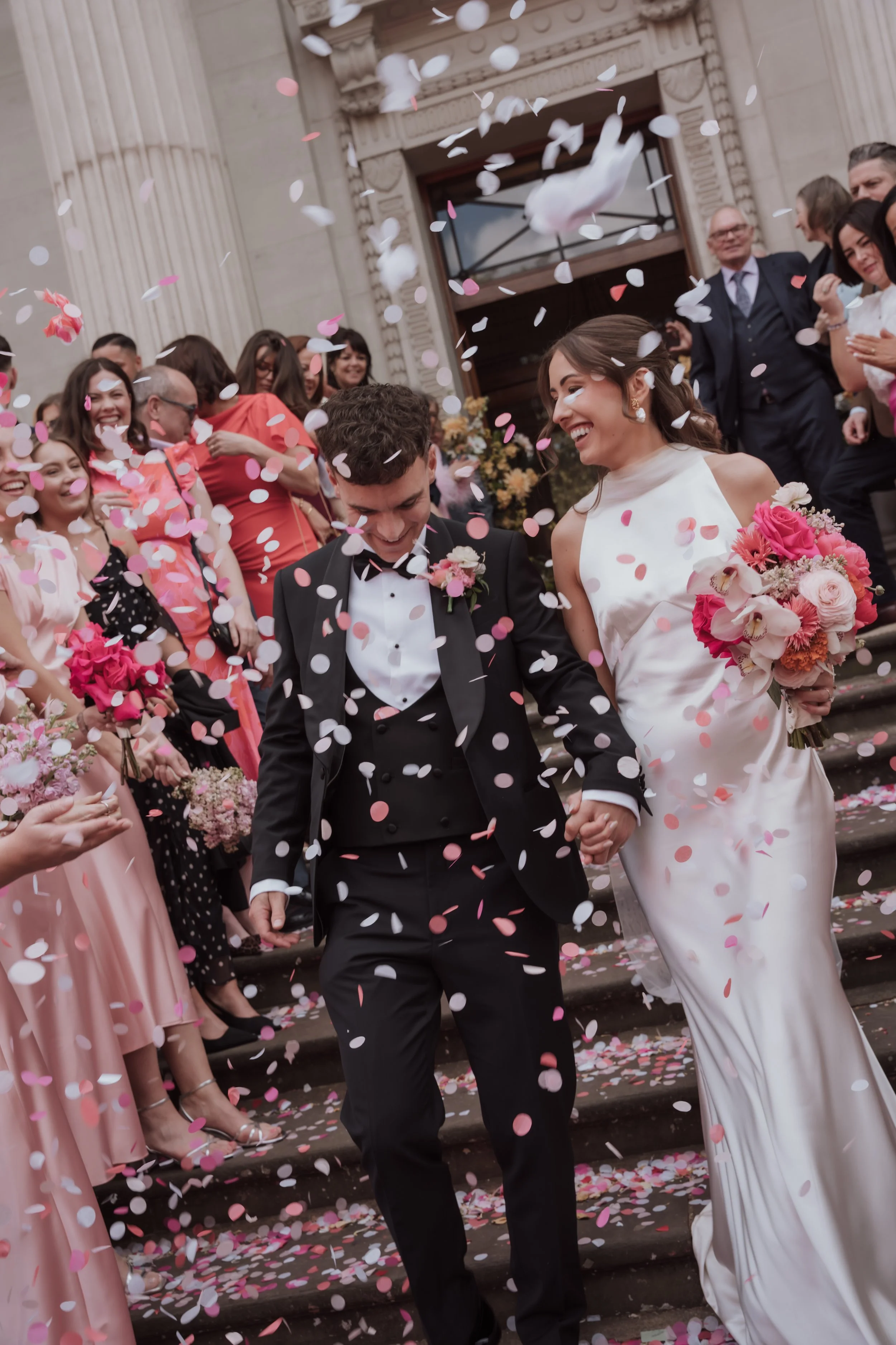 Couple confetti exit after wedding ceremony