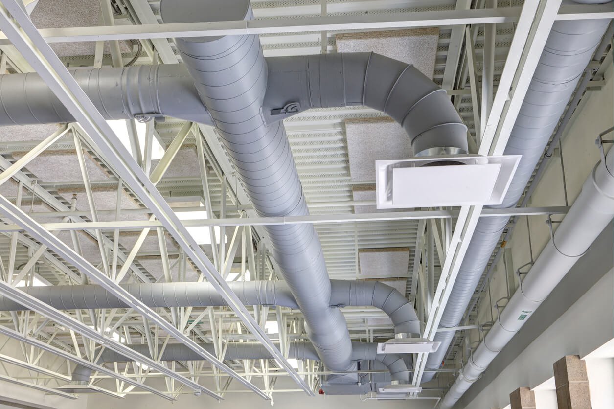 xposed modern heating and cooling ductwork in the ceiling of a commercial building