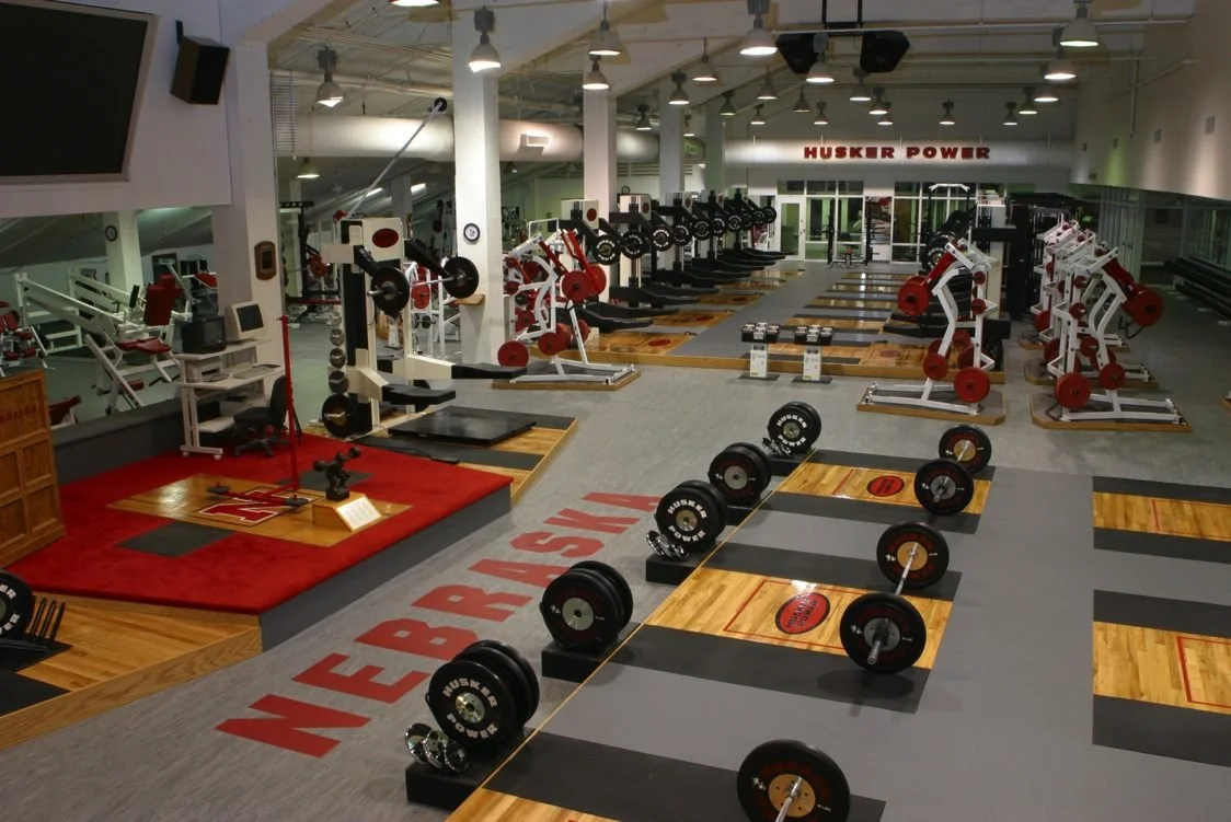 Nebraska Cornhuskers football weight room during the 1990s, representing the Huskers’ renowned strength and conditioning program.