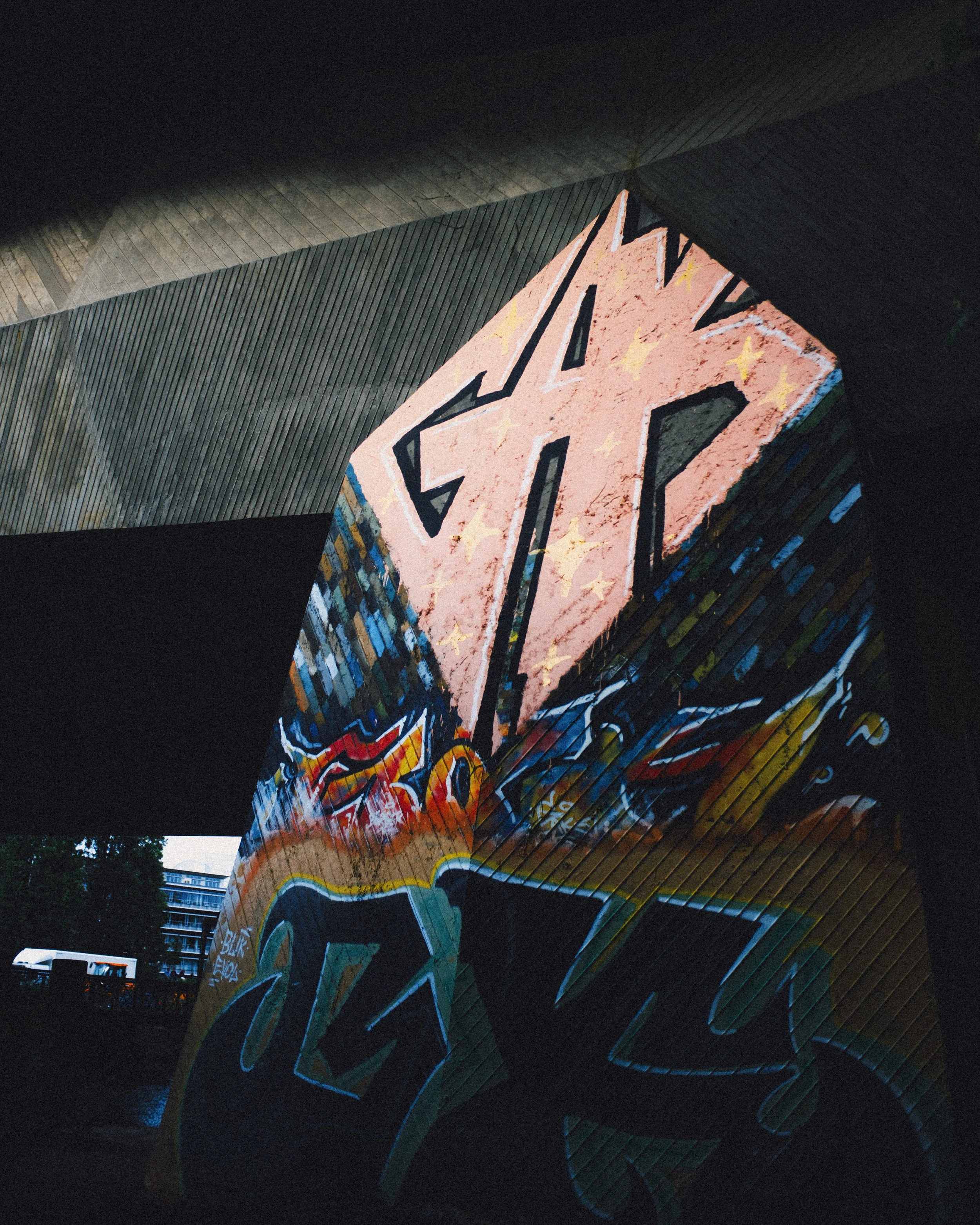 Graffiti art on a large, angled wall featuring the word 'PEACE' in bold letters, with colorful designs and yellow star accents.