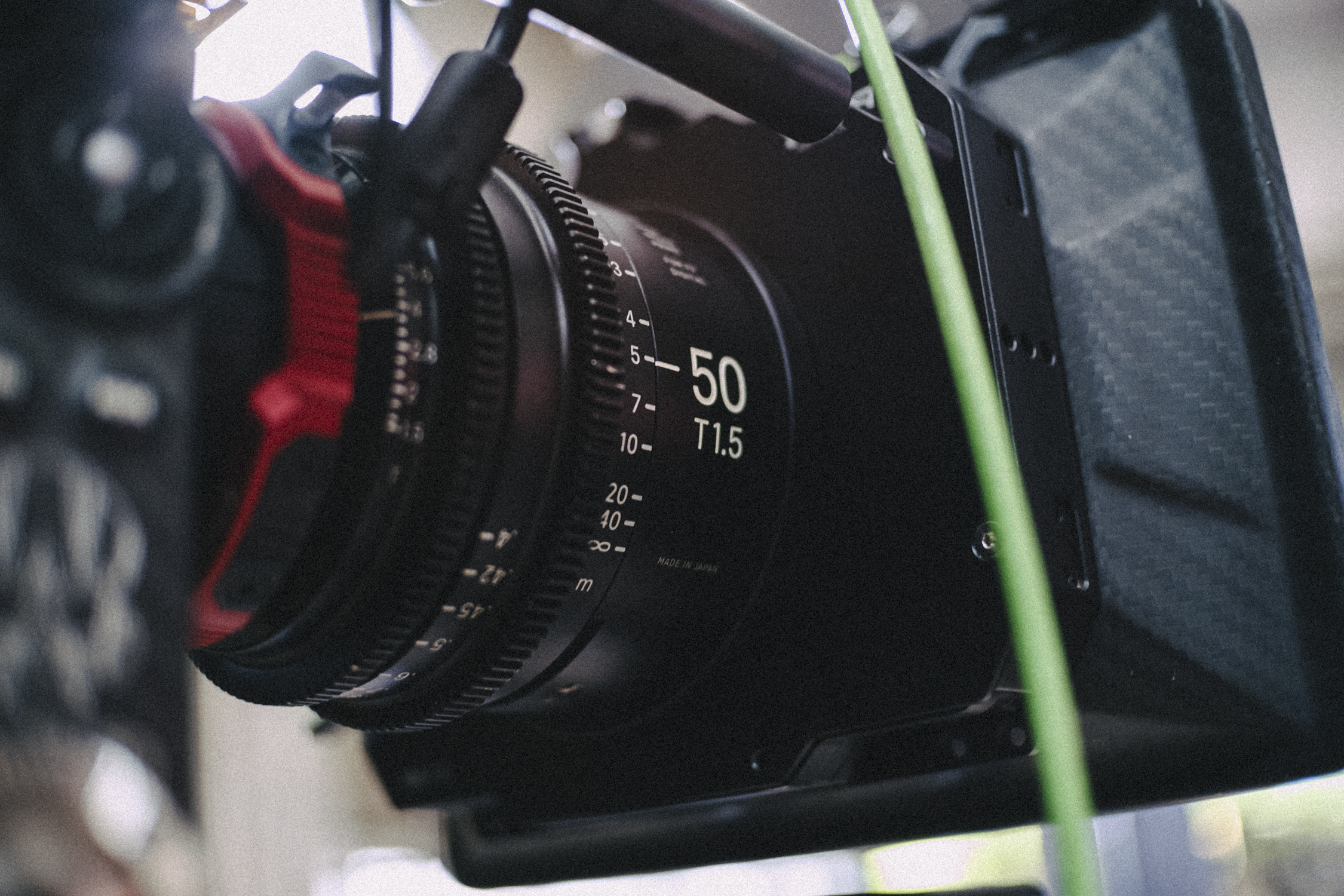 Close-up of a professional camera lens with markings indicating focus distance set to 50 millimeters and aperture T1.5, mounted on the camera body.