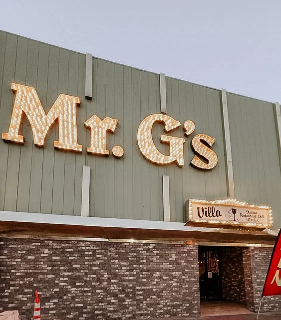 Sign for Mr. G's restaurant with large illuminated letters on the building's exterior.
