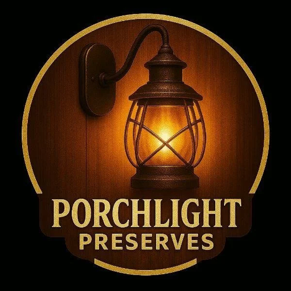A vintage outdoor lantern illuminating a wooden wall with the text 'Porchlight Preserves' below.
