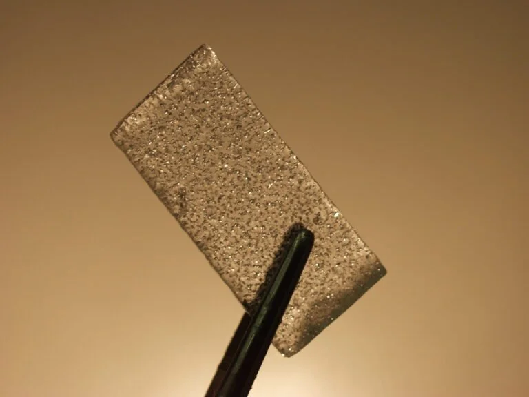 A piece of ice held up, with visible ancient air bubbles trapped within.