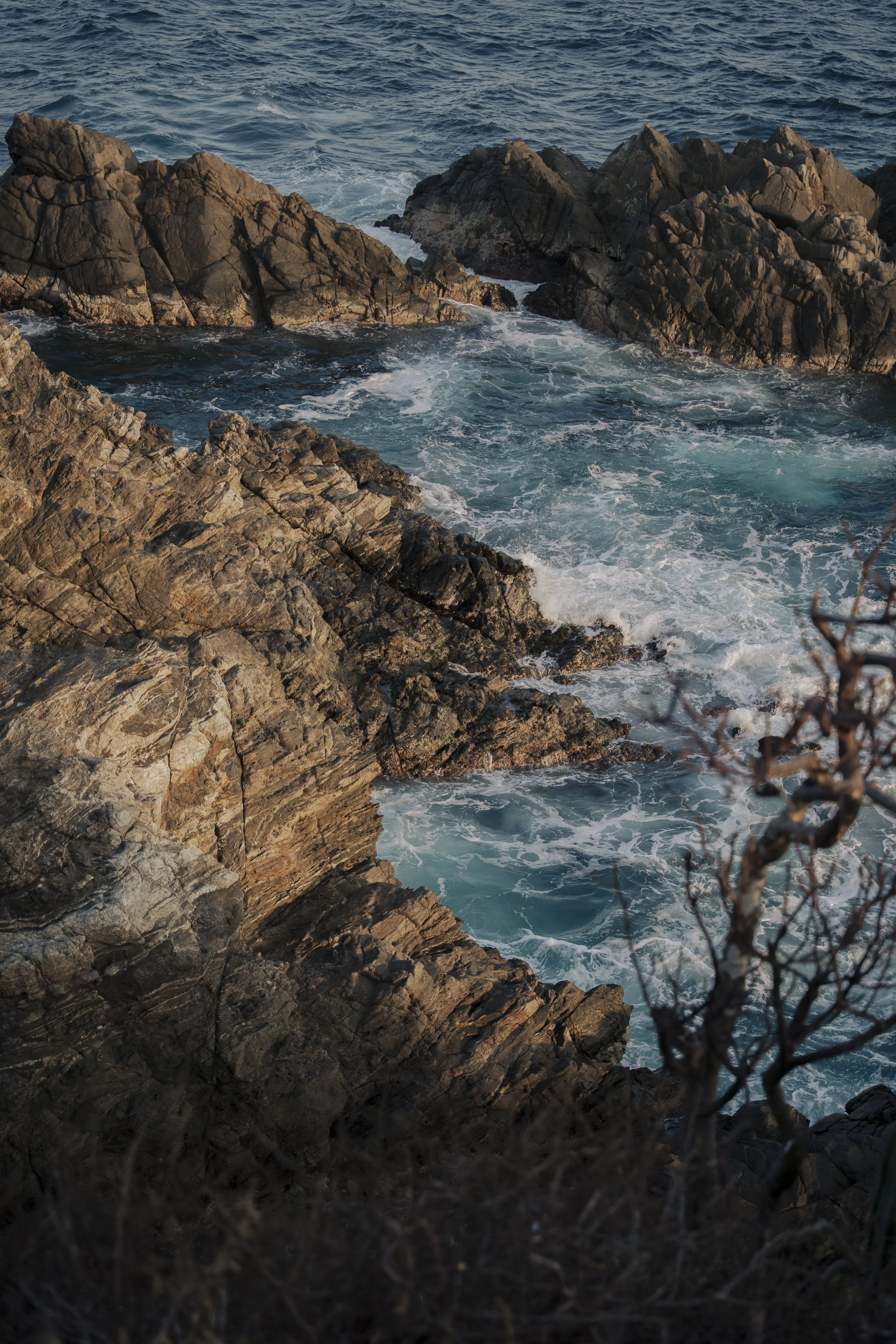 Olas golpeando rocas en la orilla del mar al atardecer en Zipolite, Oaxaca, Mexico. Vista desde Chiflon
