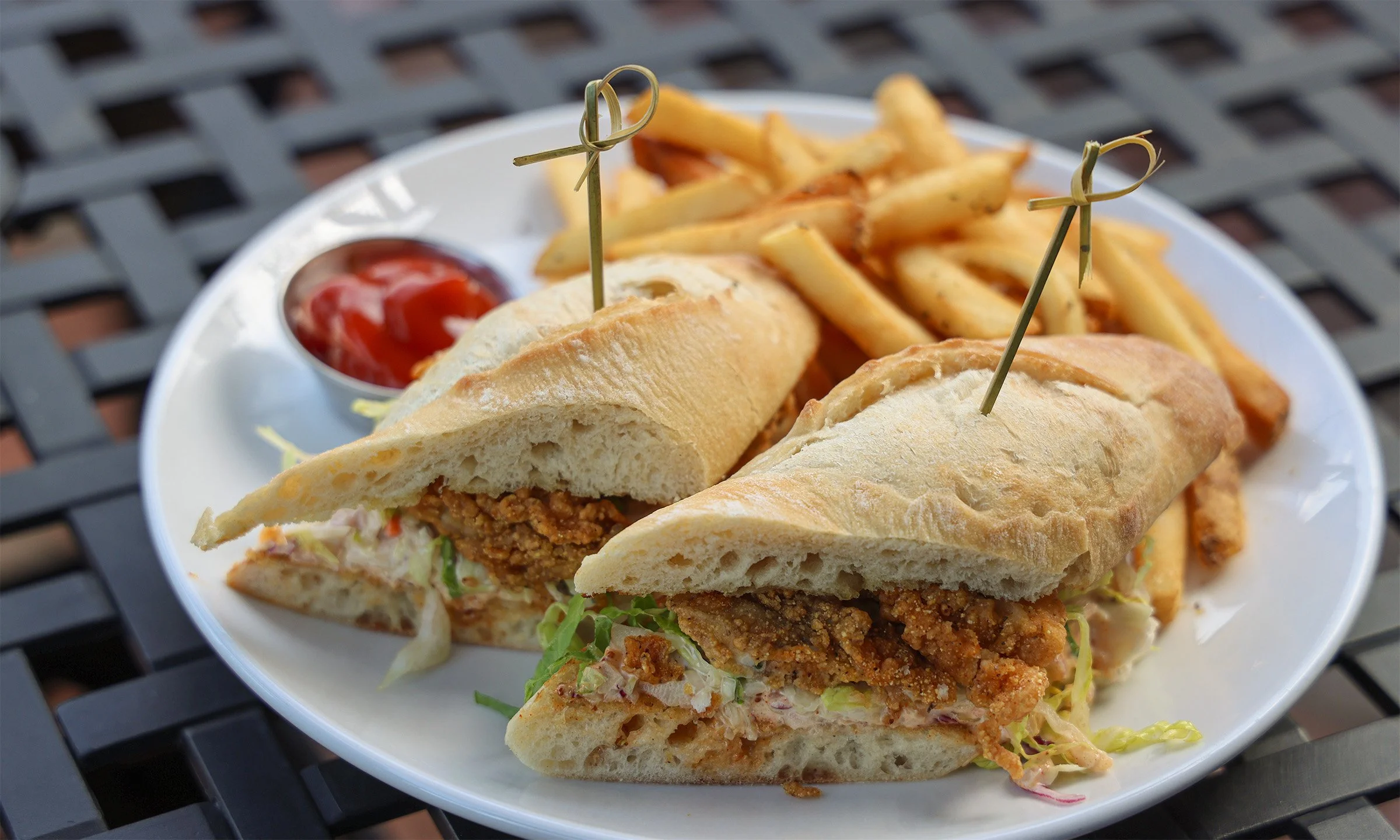 Plate with fried chicken sandwich halves, French fries, and ketchup