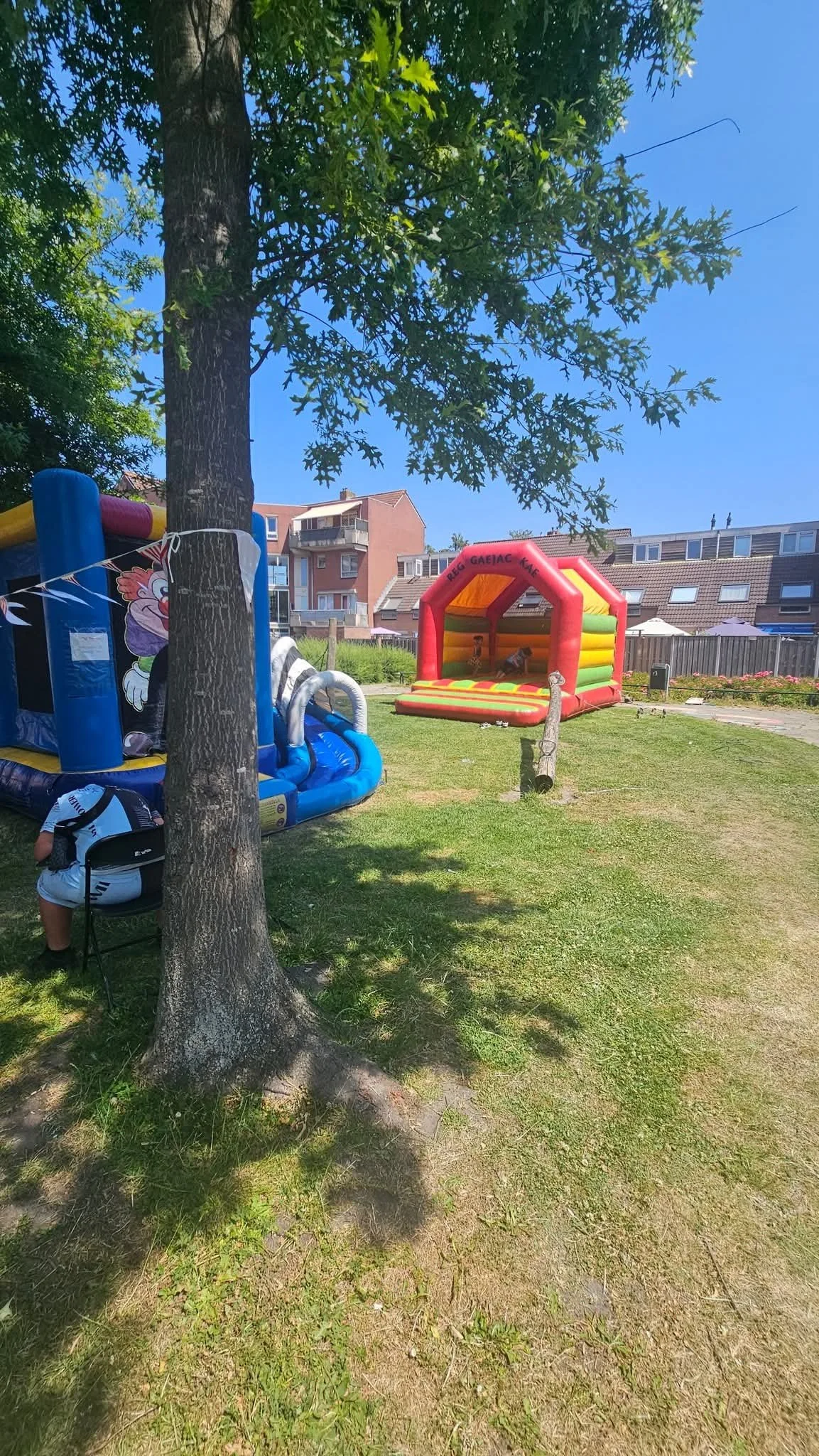 Springkussens op een kinderfeestje buiten met spelende kinderen en kleurrijke attracties