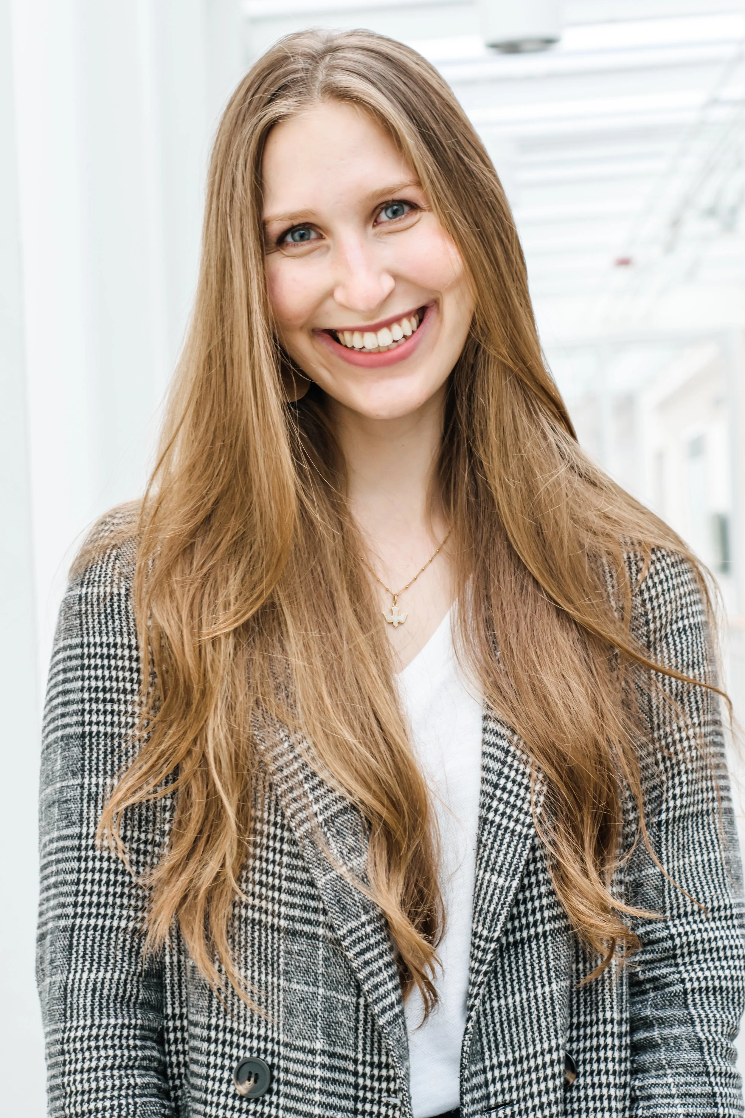 Amy Crouch, smiling, wearing a houndstooth blazer