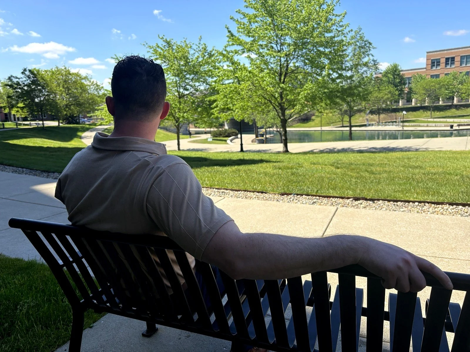 Patrick Michaud, Indianapolis business consultant and founder of Ascendant Advising Group, seated on a bench overlooking a park