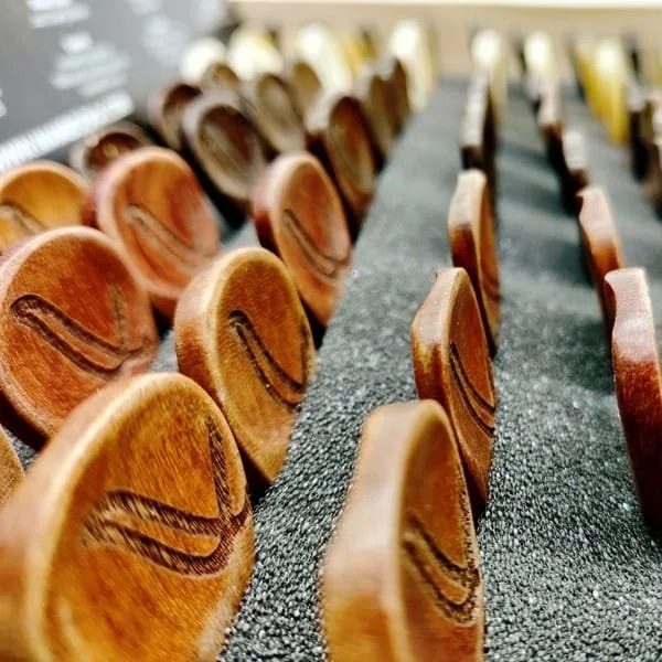 Close-up of wooden guitar picks with contours in a display box