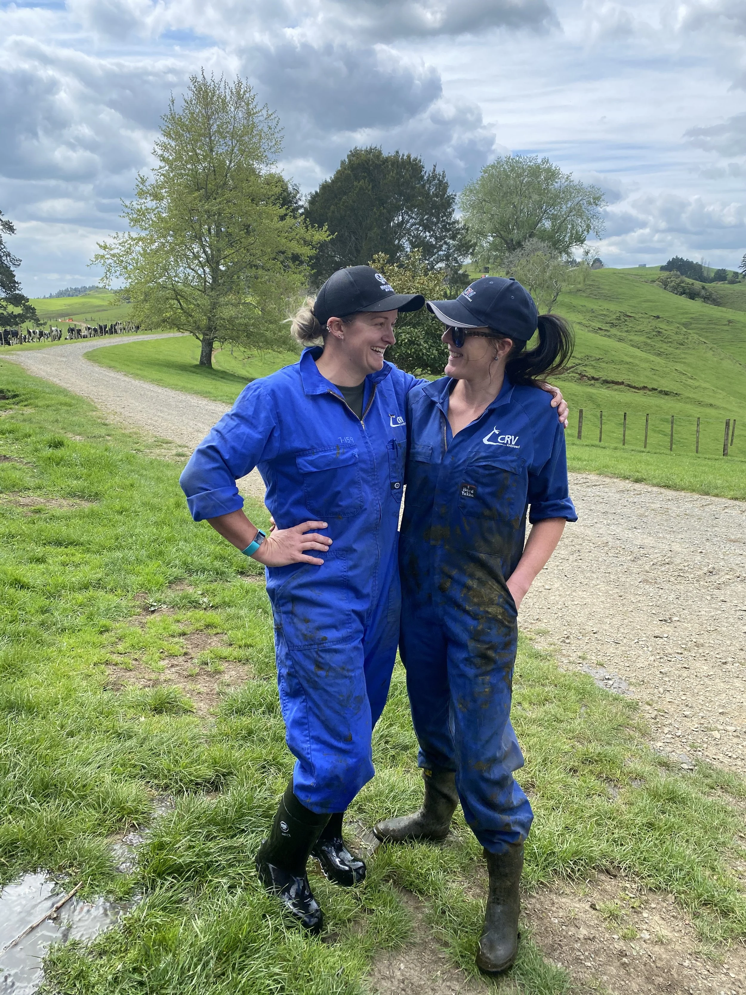 Two qualified AB Technicians in blue overalls standing in green field