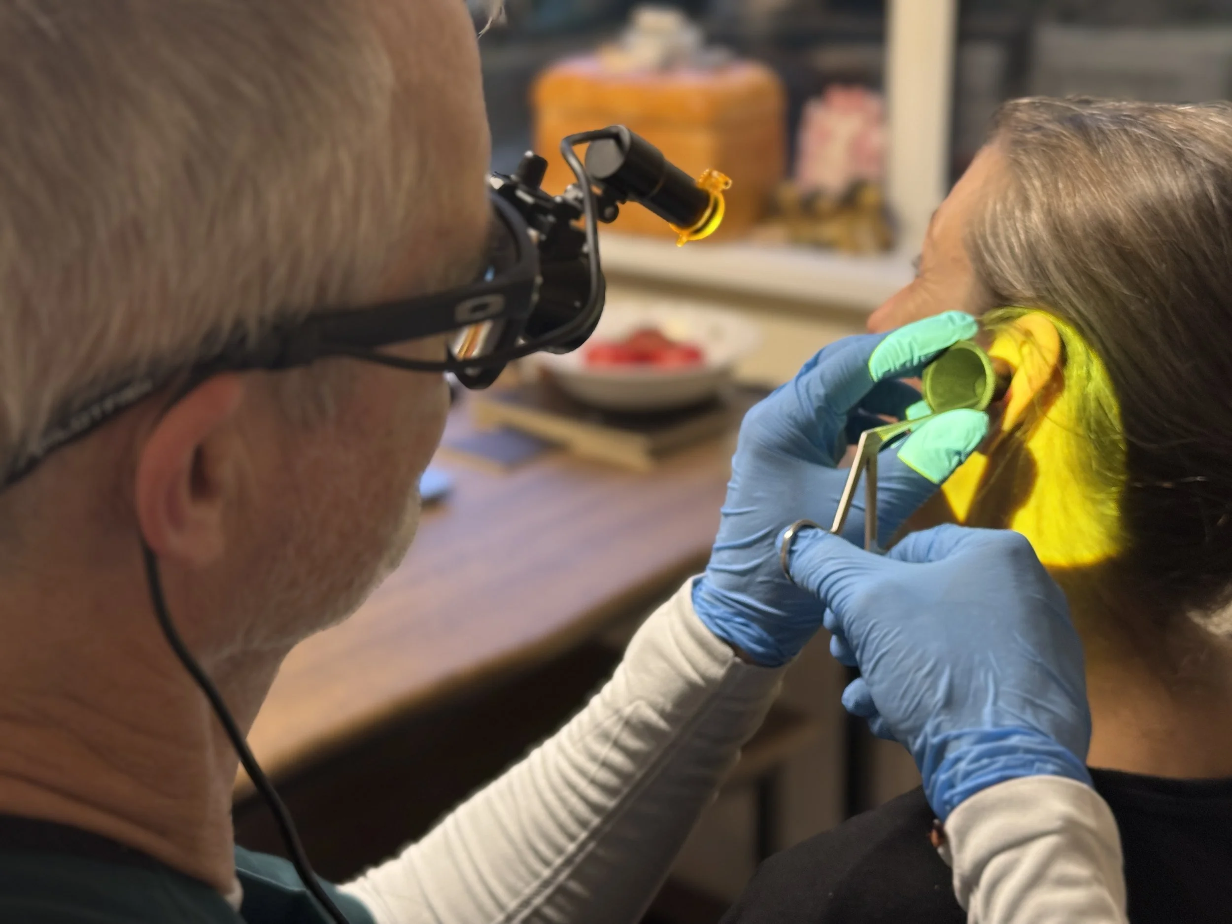 Alan performing manual ear wax removal using specialist instruments during a home visit.