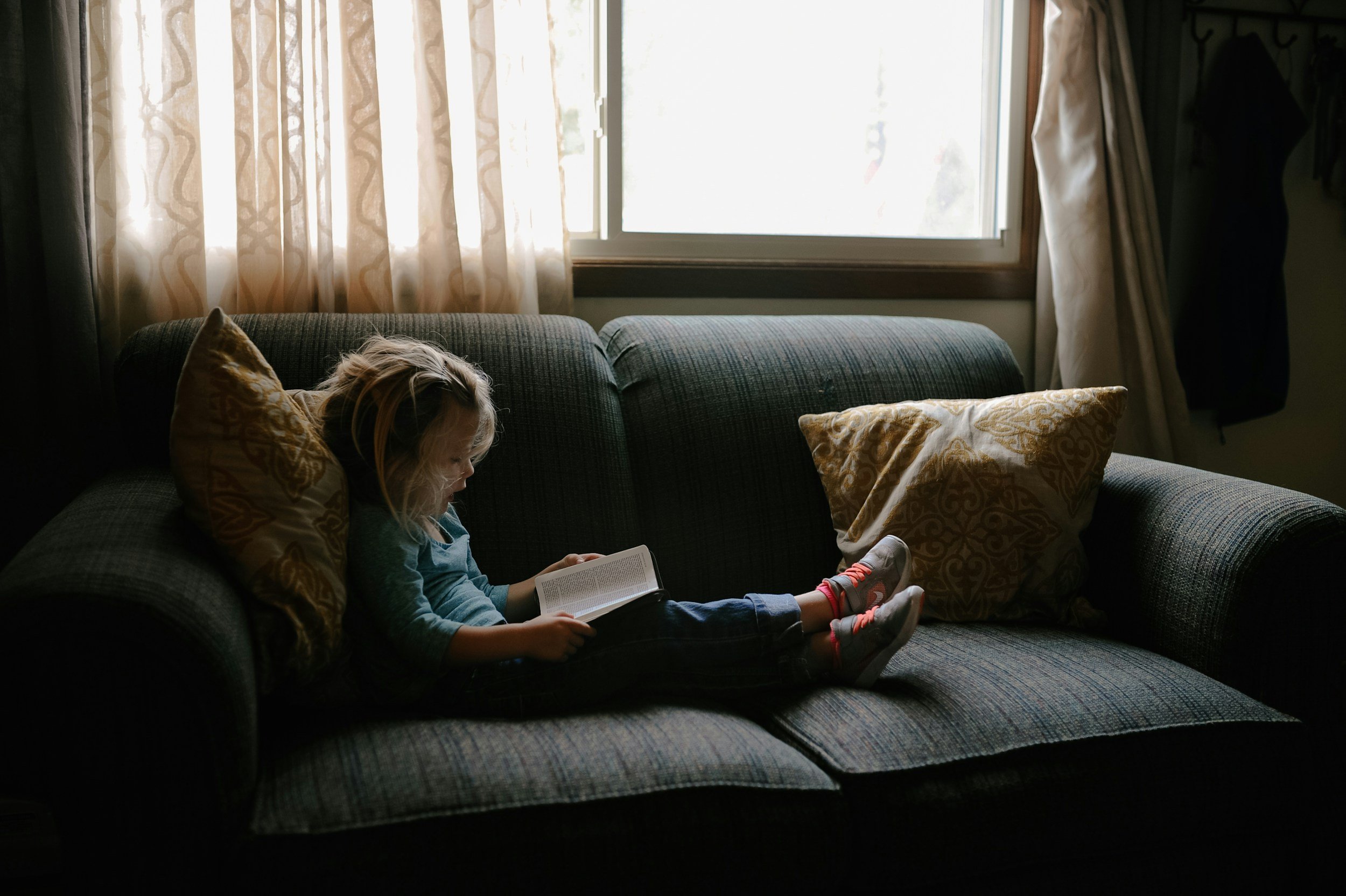 Young student reading a book during a one-on-one tutoring session.