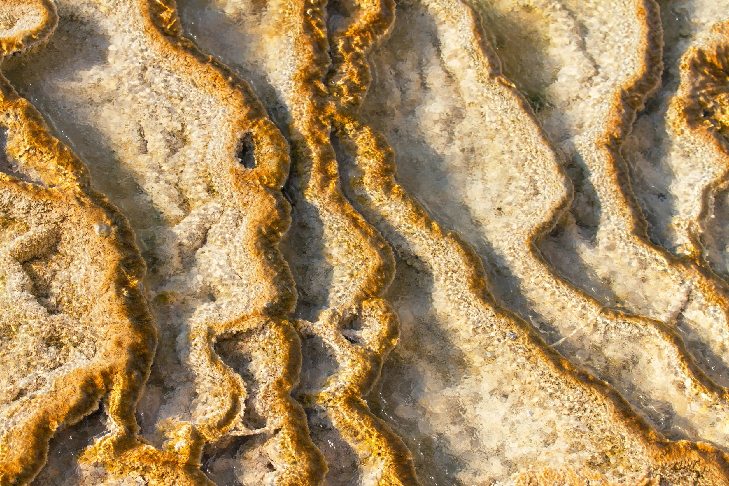 Textured layers of golden and grey stone