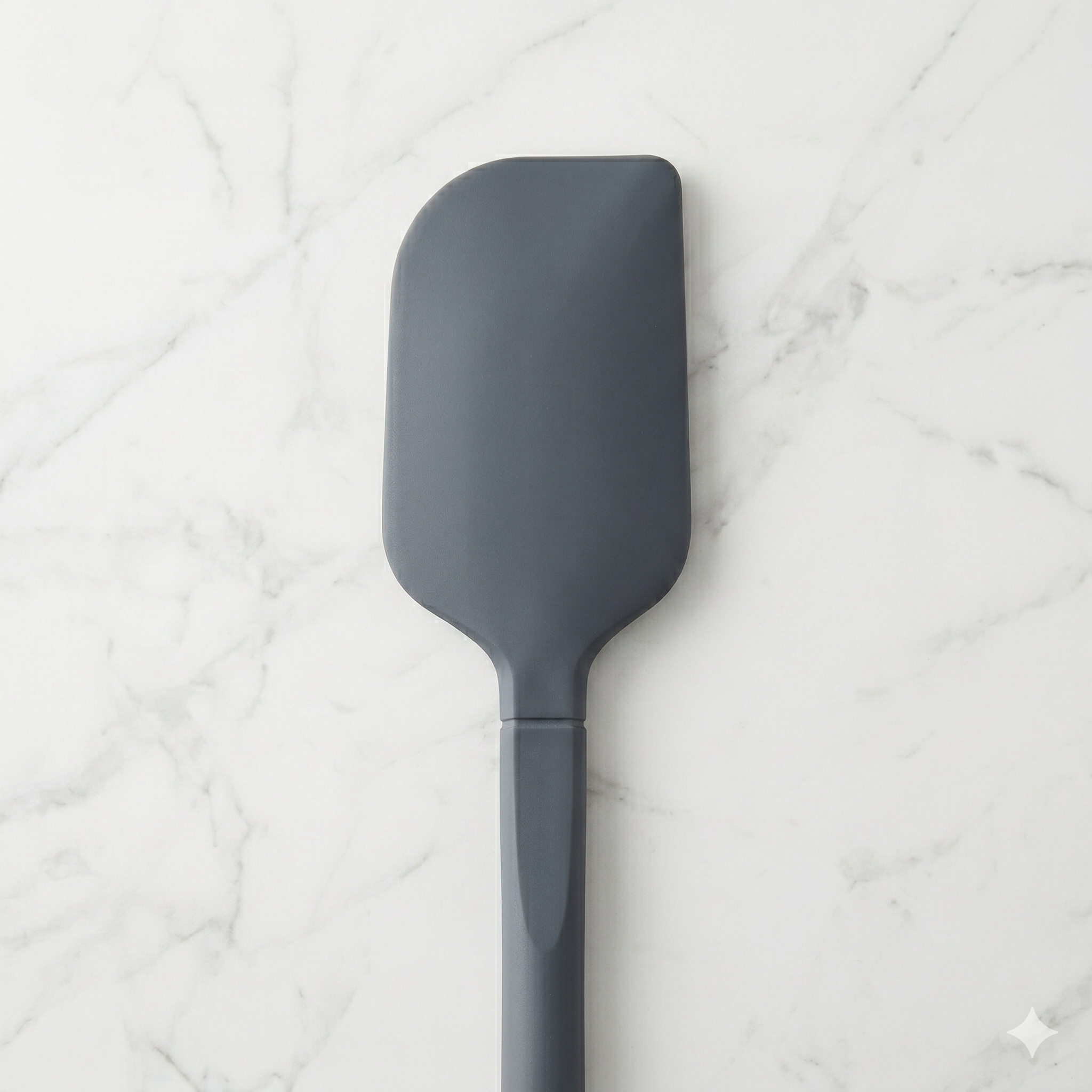 A seamless, high-heat silicone spatula centered on a marble surface—a durable BIFL tool for deliberate folding.
